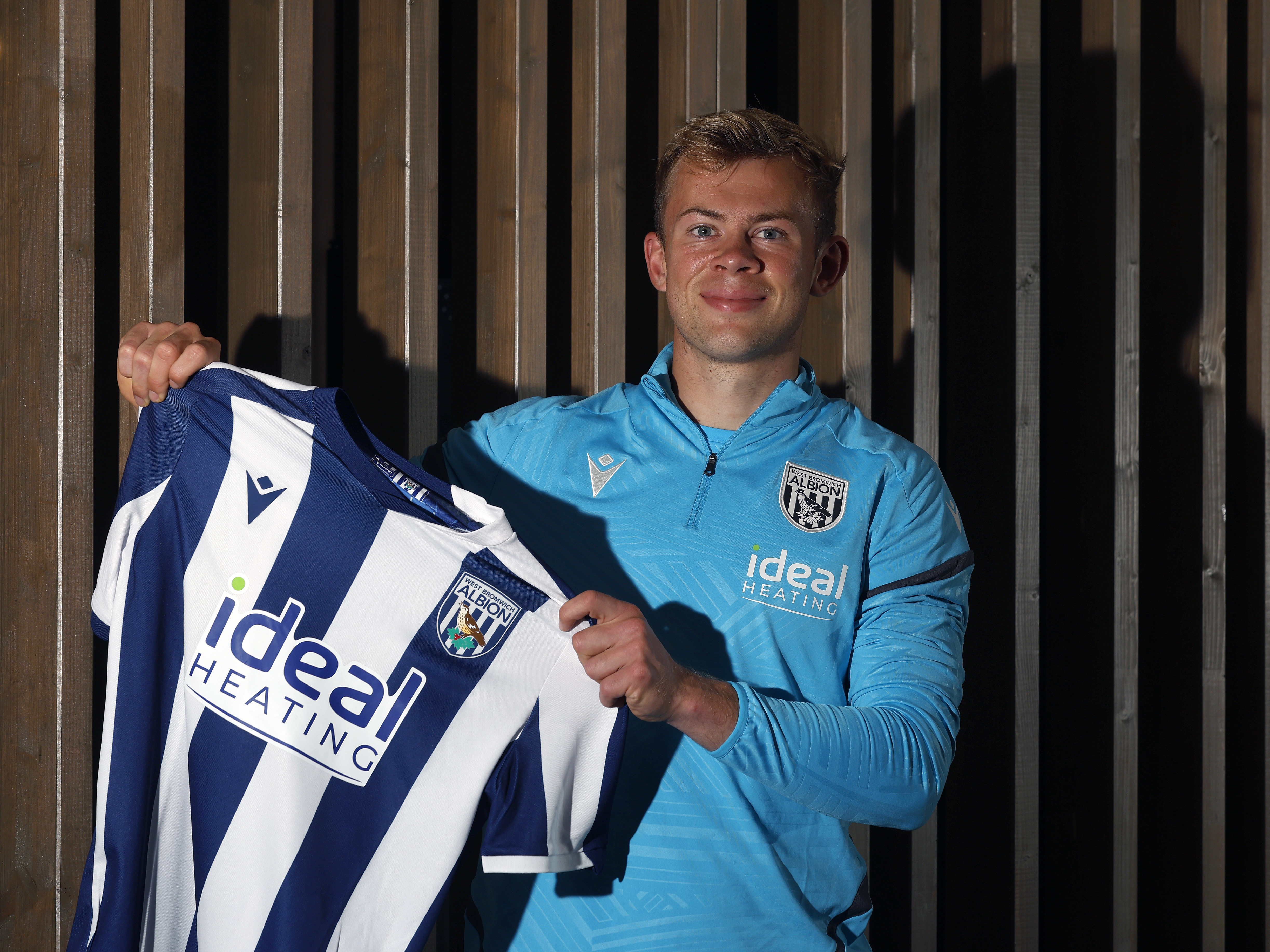 An image of Aune Heggebo holding up an Albion home shirt