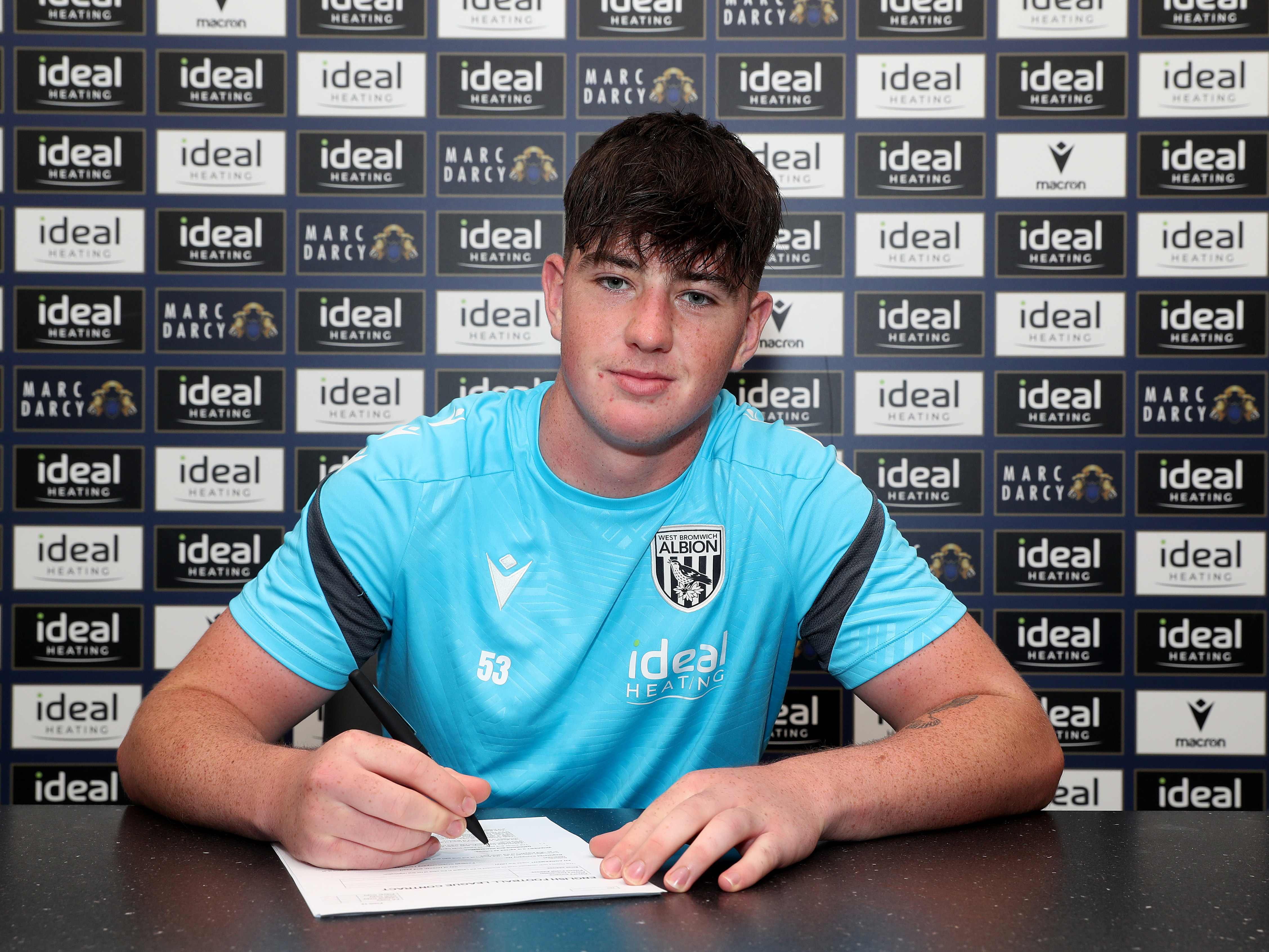 A photo of Louis Brady signing his first professional Albion contract