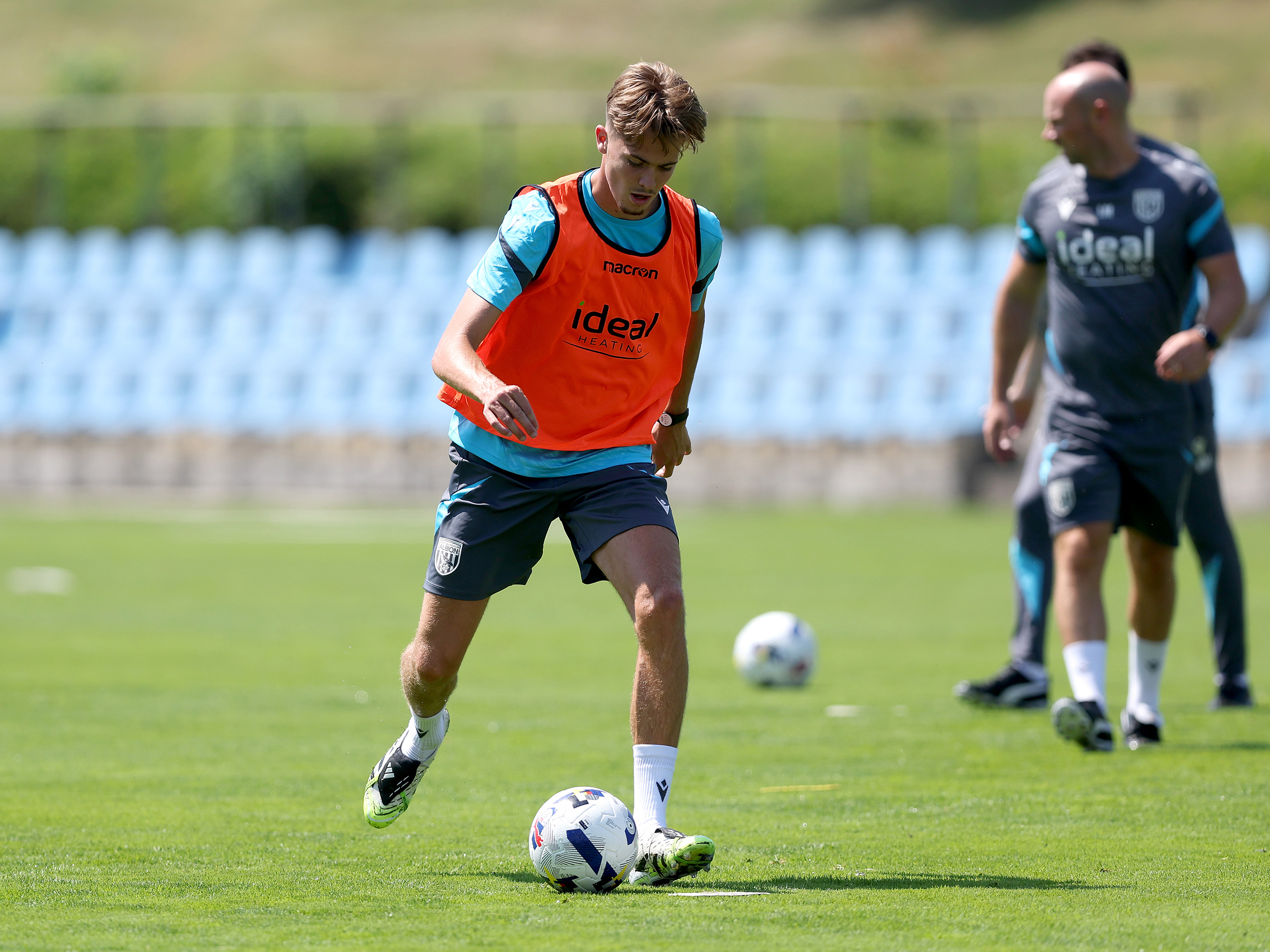 Isaac Price on the ball during a training session while wearing an orange bib
