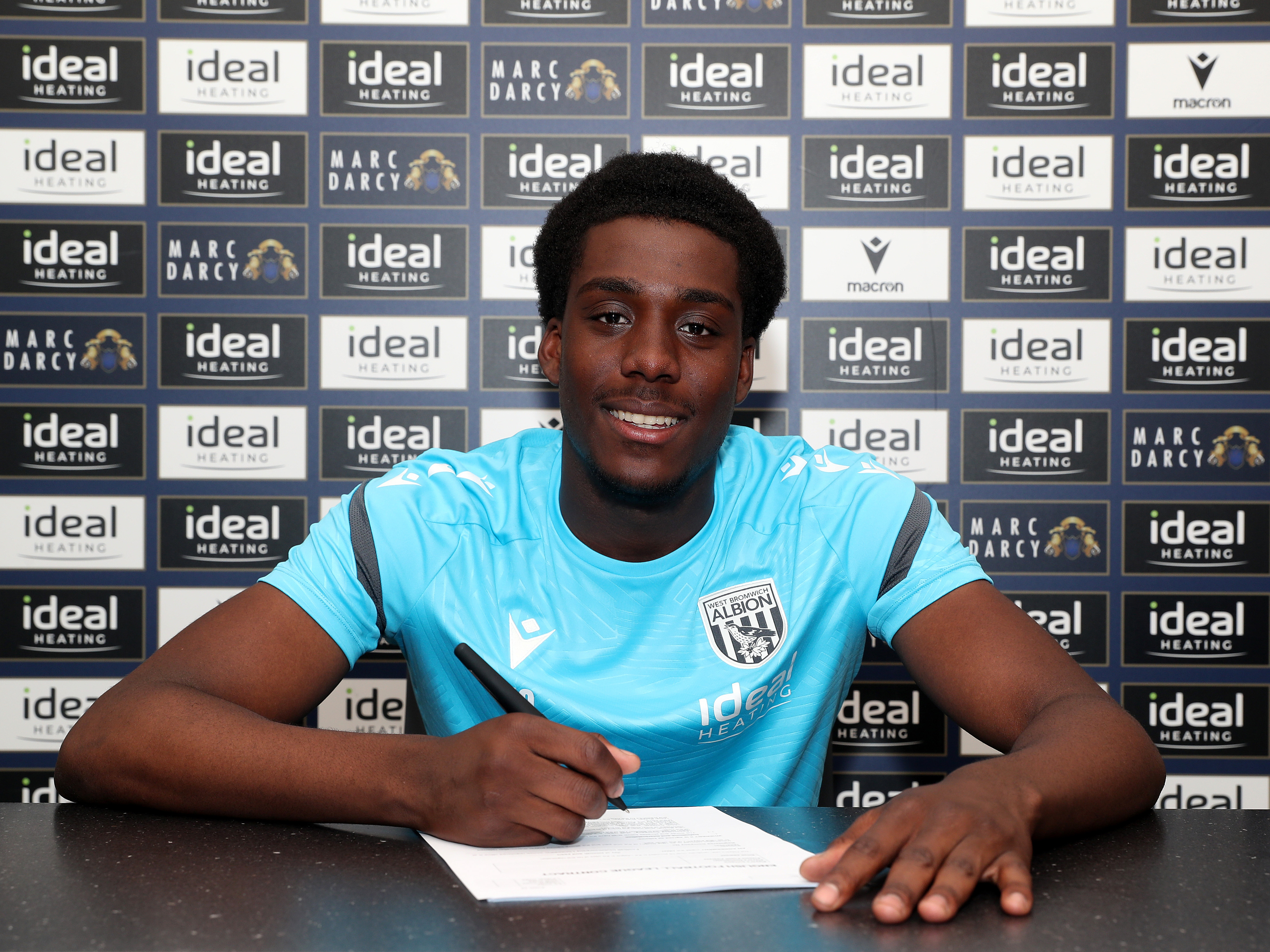 A photo of Albion U21 midfielder Souleyman Mandey signing an extended contract 