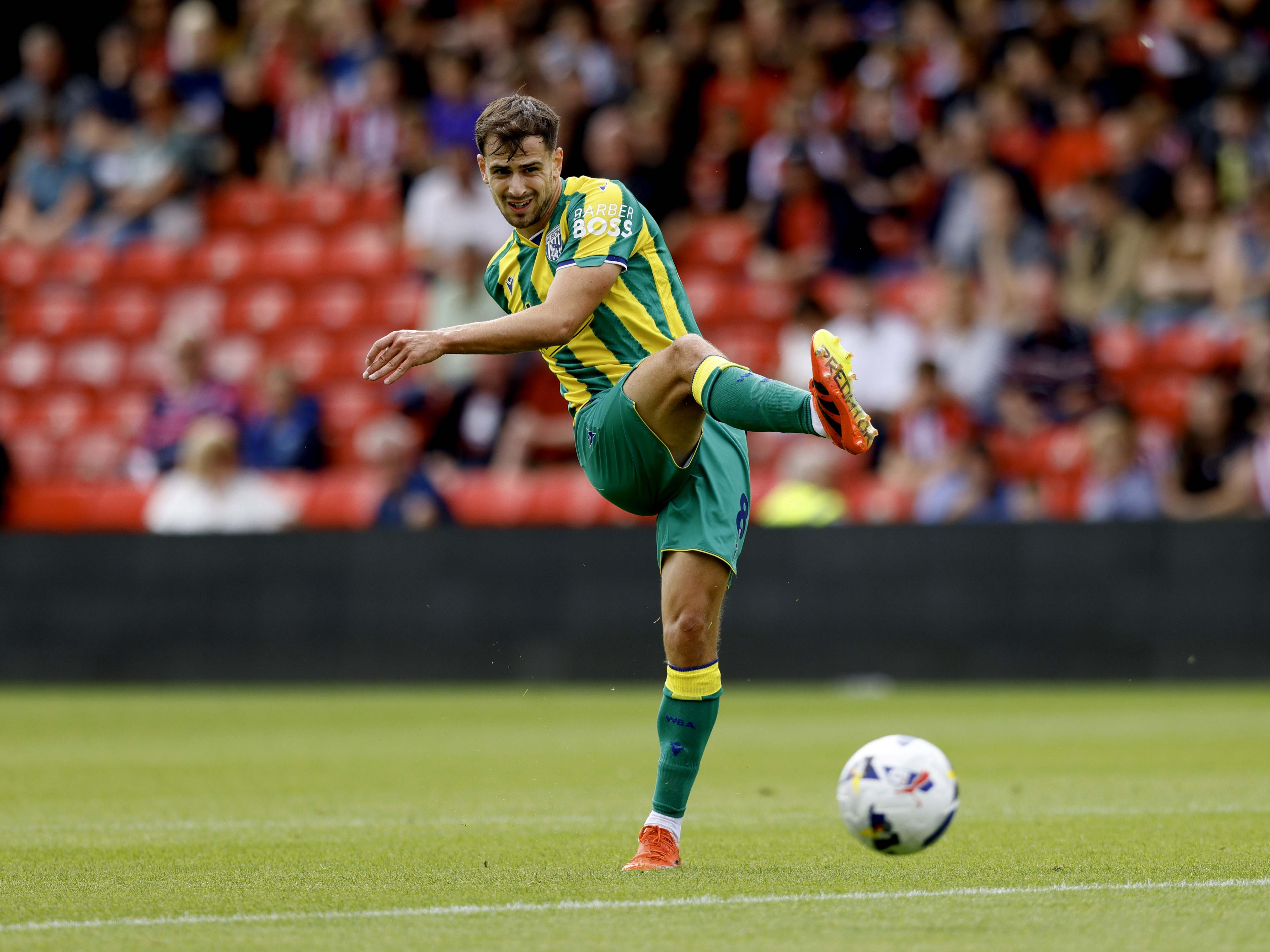 A photo of Albion midfielder Jayson Molumby in the 2025/26 green and yellow away kit