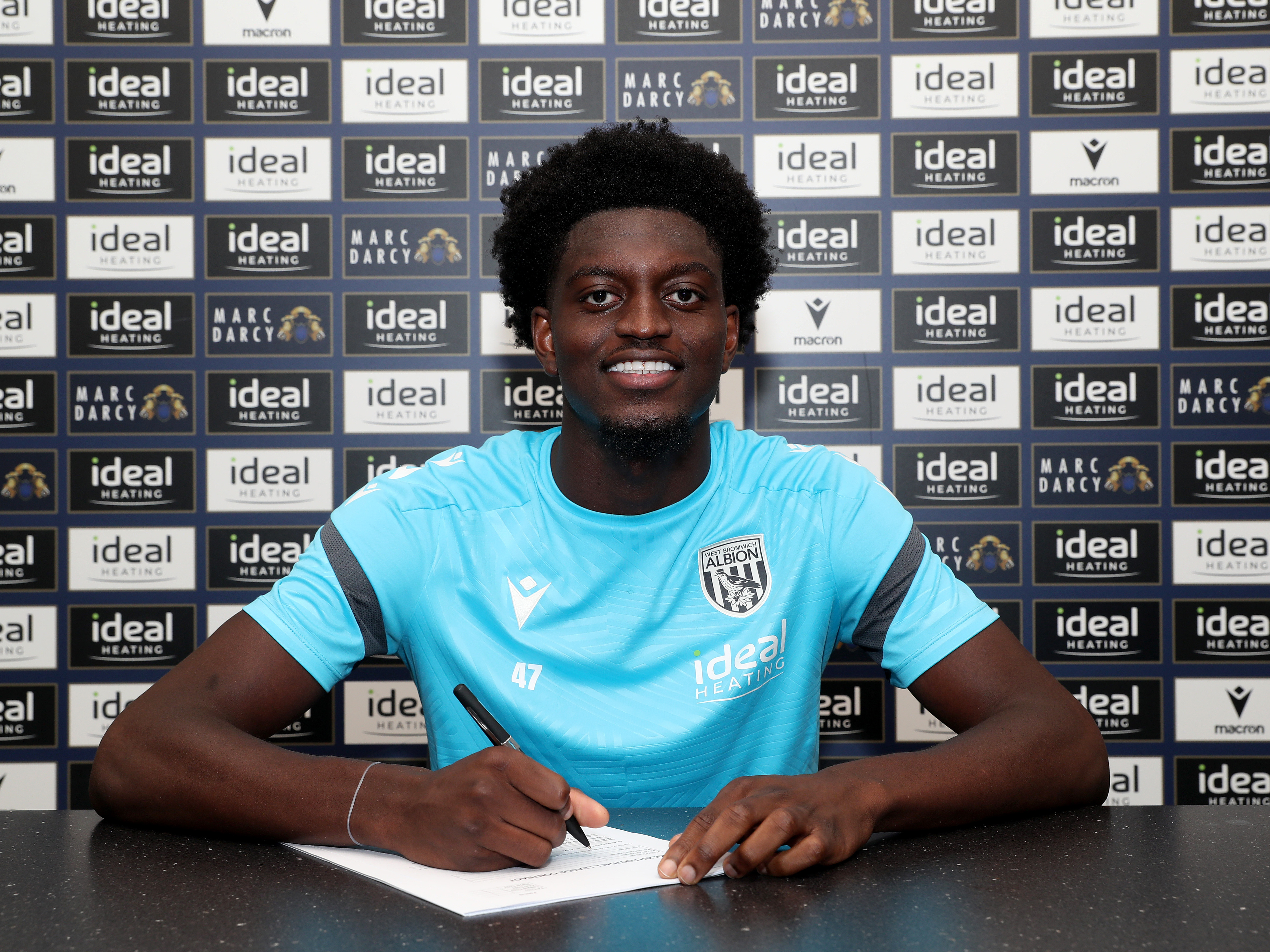 A photo of Albion U21 striker Michael Parker signing an extended contract 