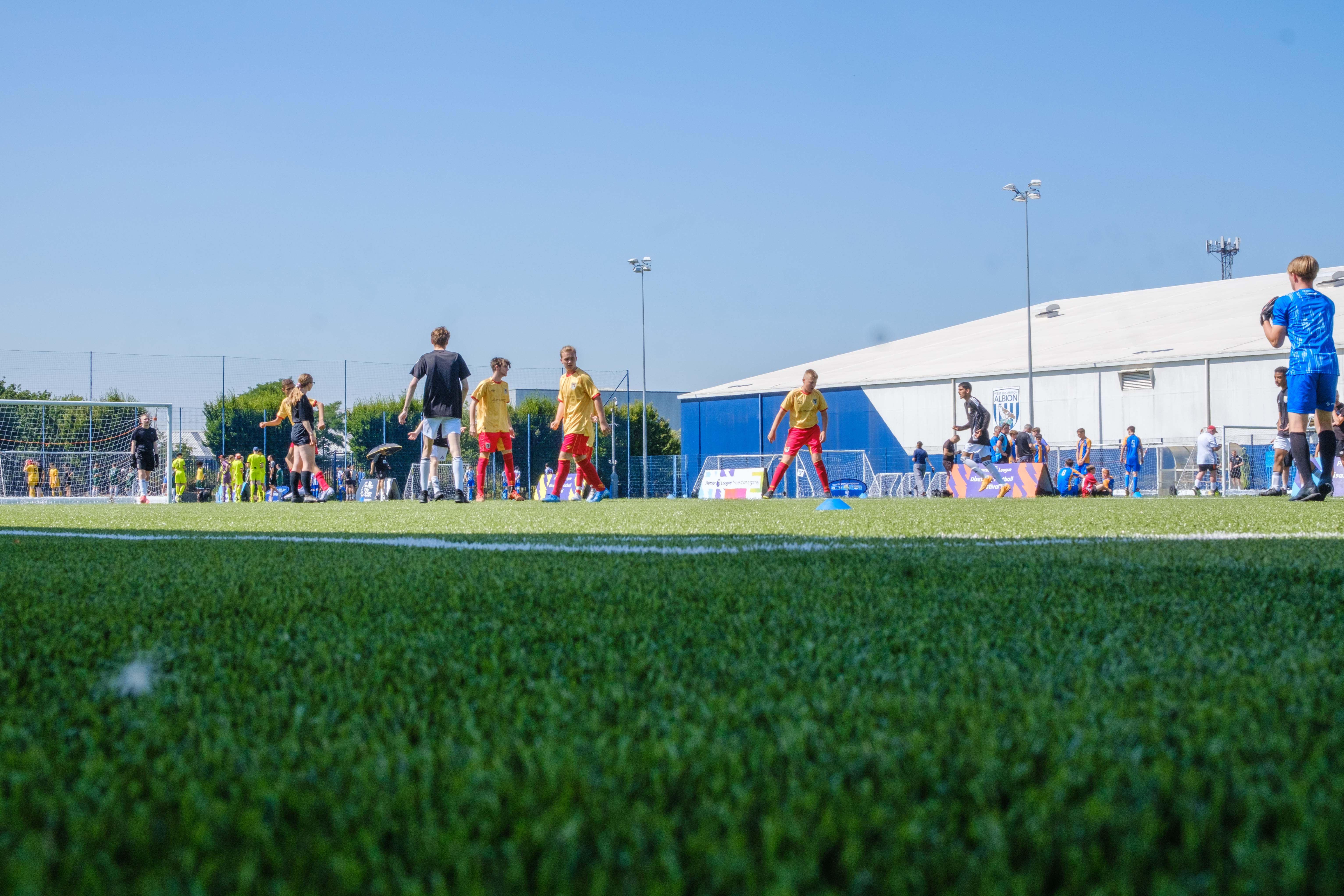 Wide shot of participants on the pitch with the Academy Dome in the background.