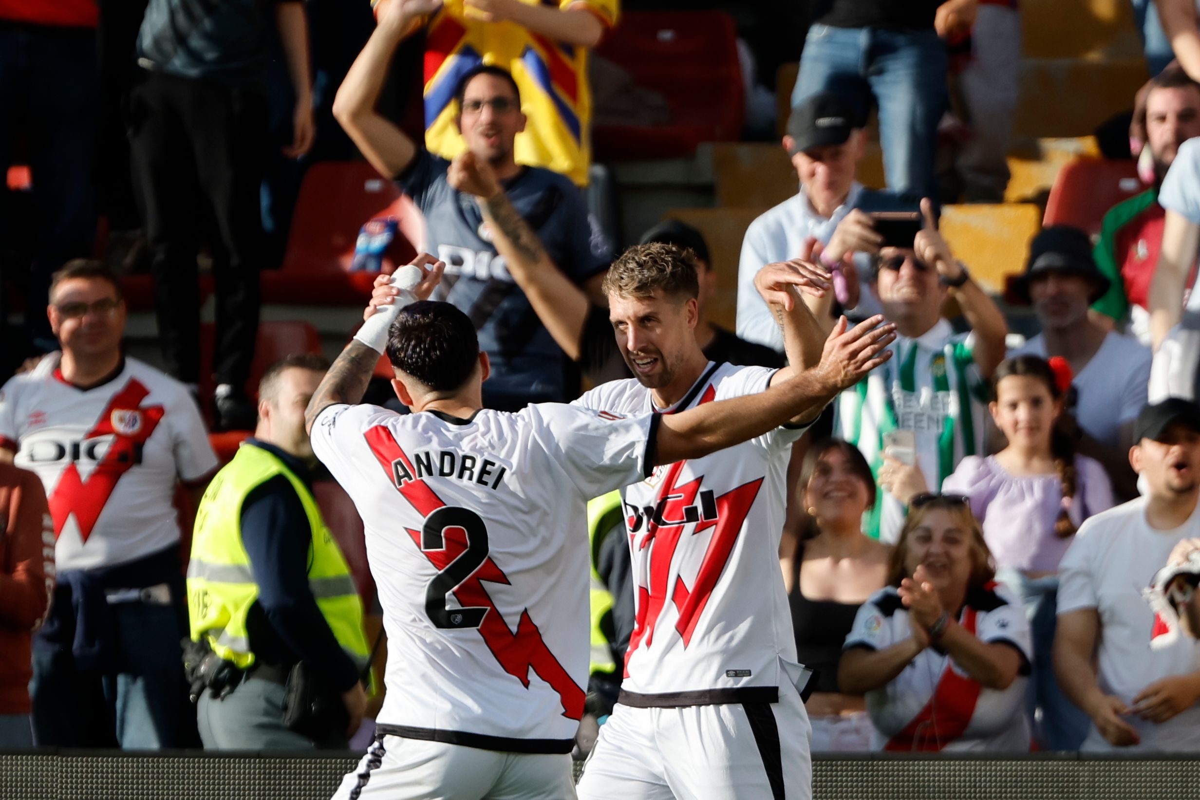 Two Rayo Vallecano players celebrate a goal in their home kit