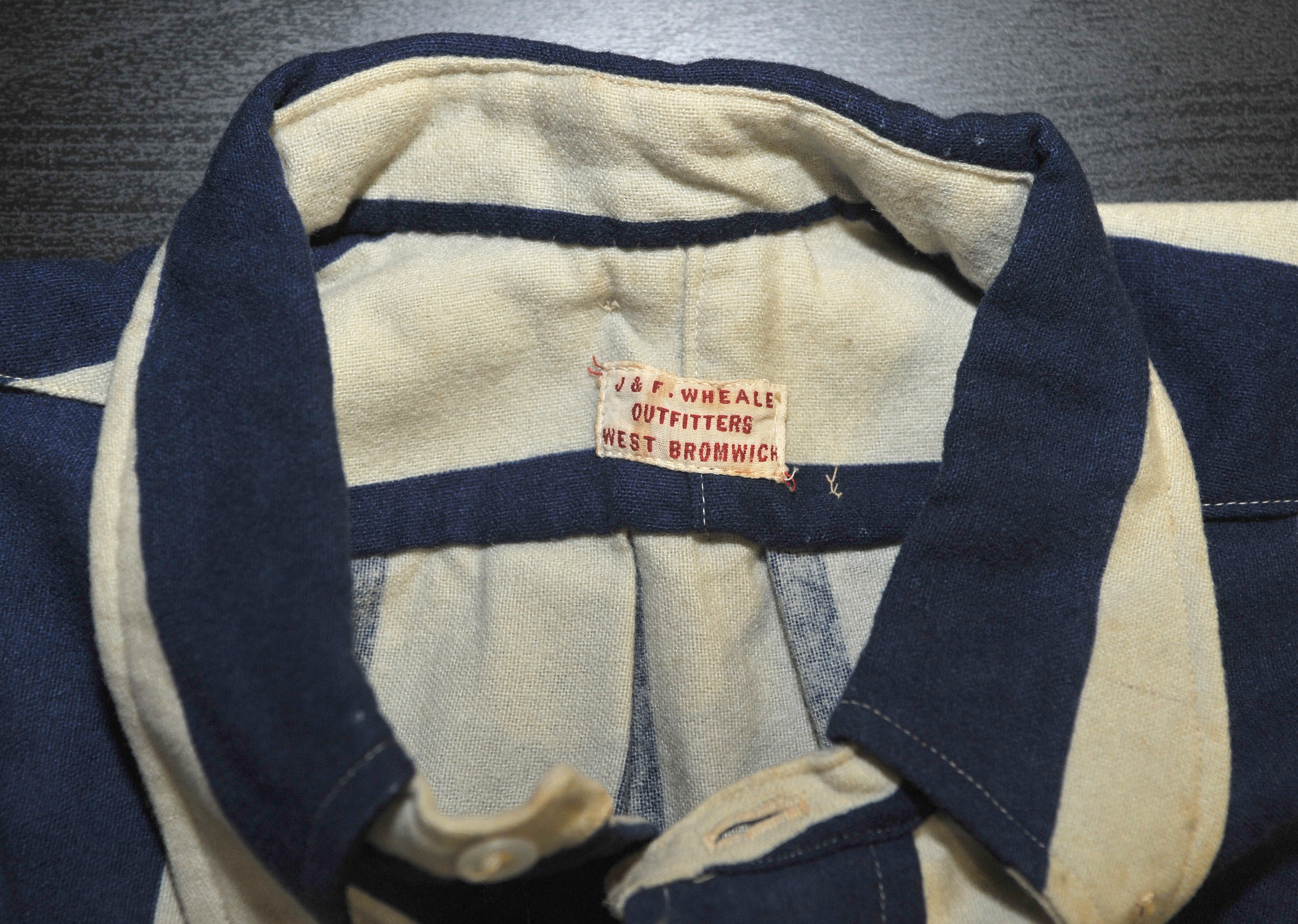 Close up of shirt label featuring J&F Wheale Outfitters West Bromwich 