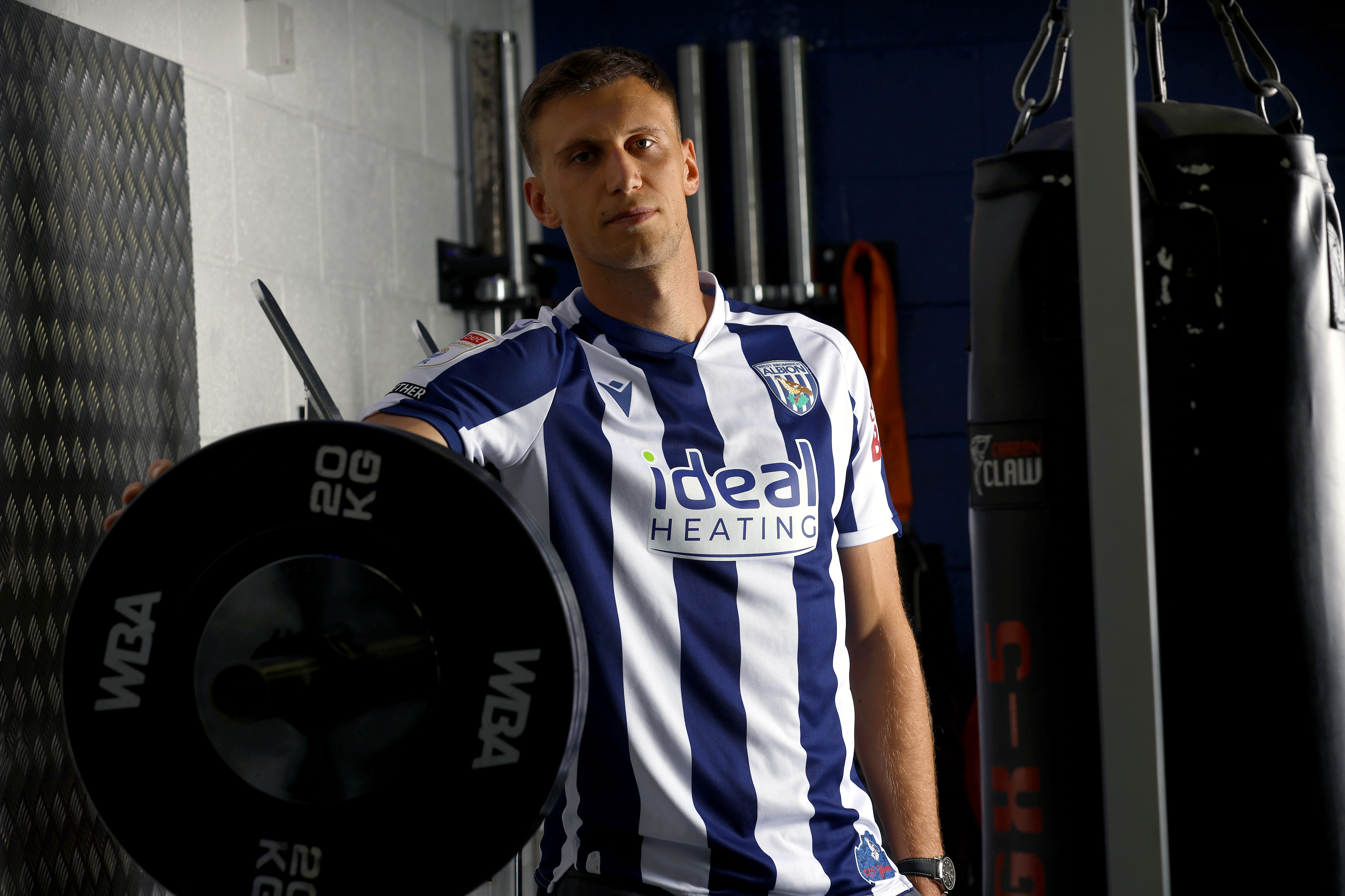Krystian Bielik in a home shirt in the gym looking at the camera 