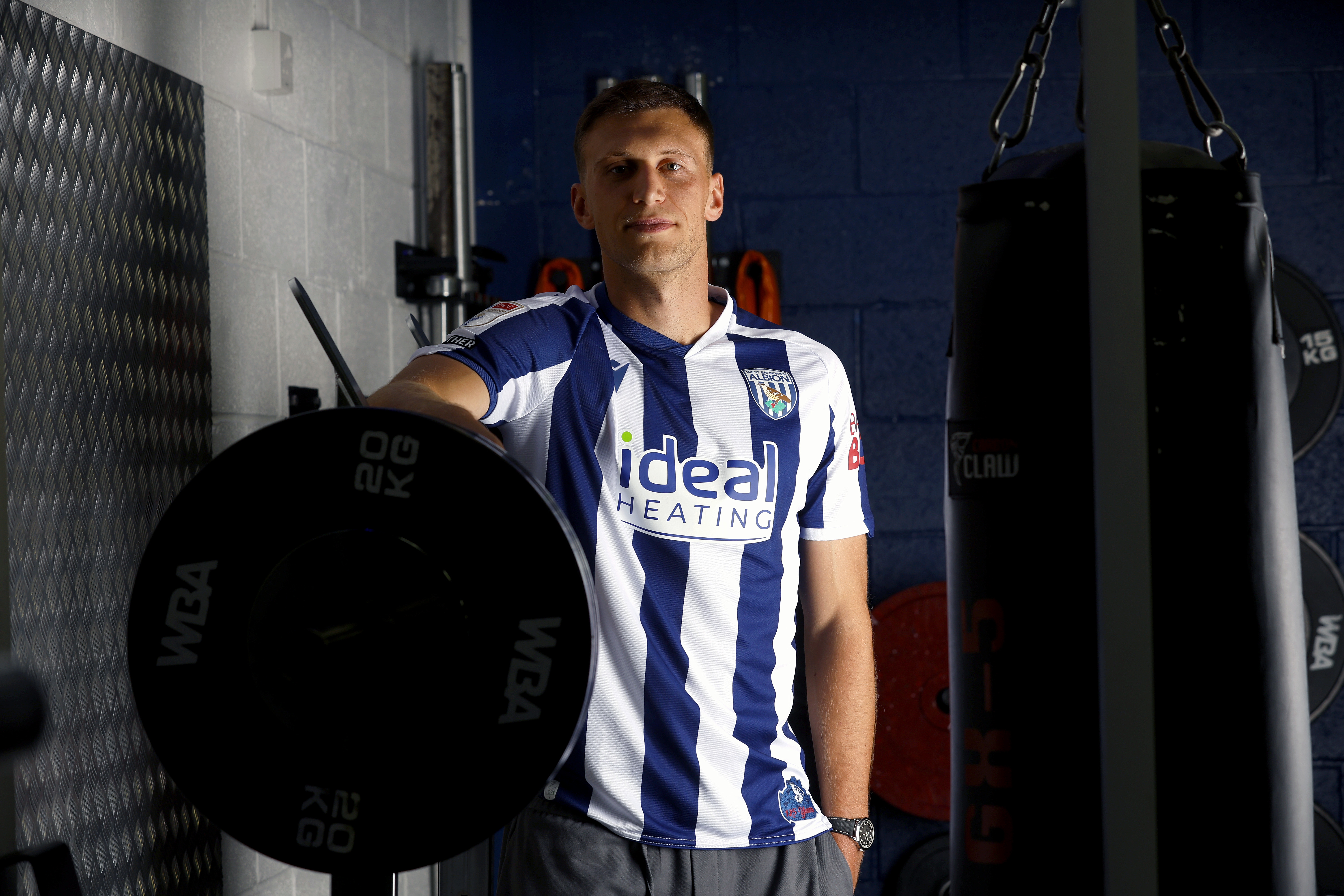 Krystian Bielik in a home shirt in the gym looking at the camera 