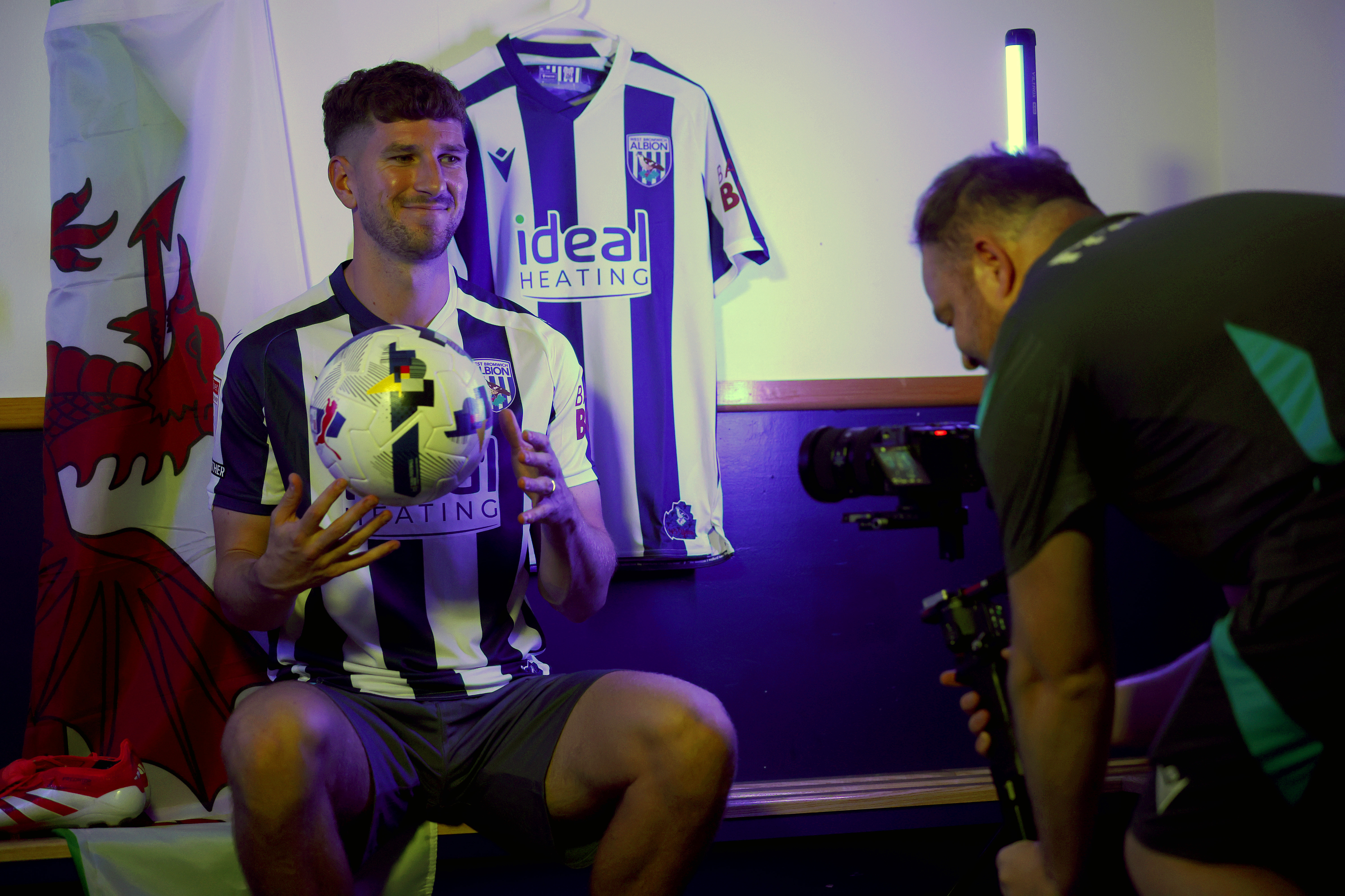 Chris Mepham smiling while sat on a bench in home kit 