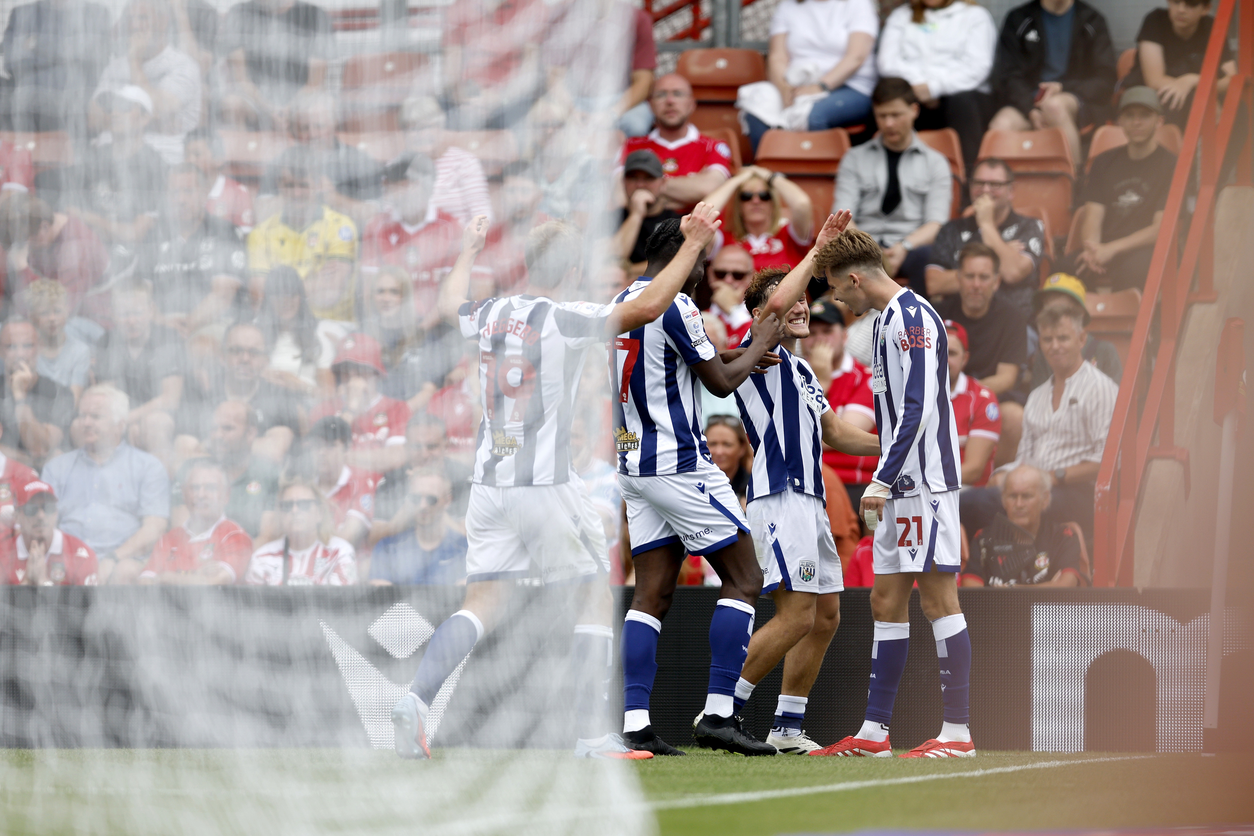 Isaac Price celebrates scoring a header against Wrexham with team-mates