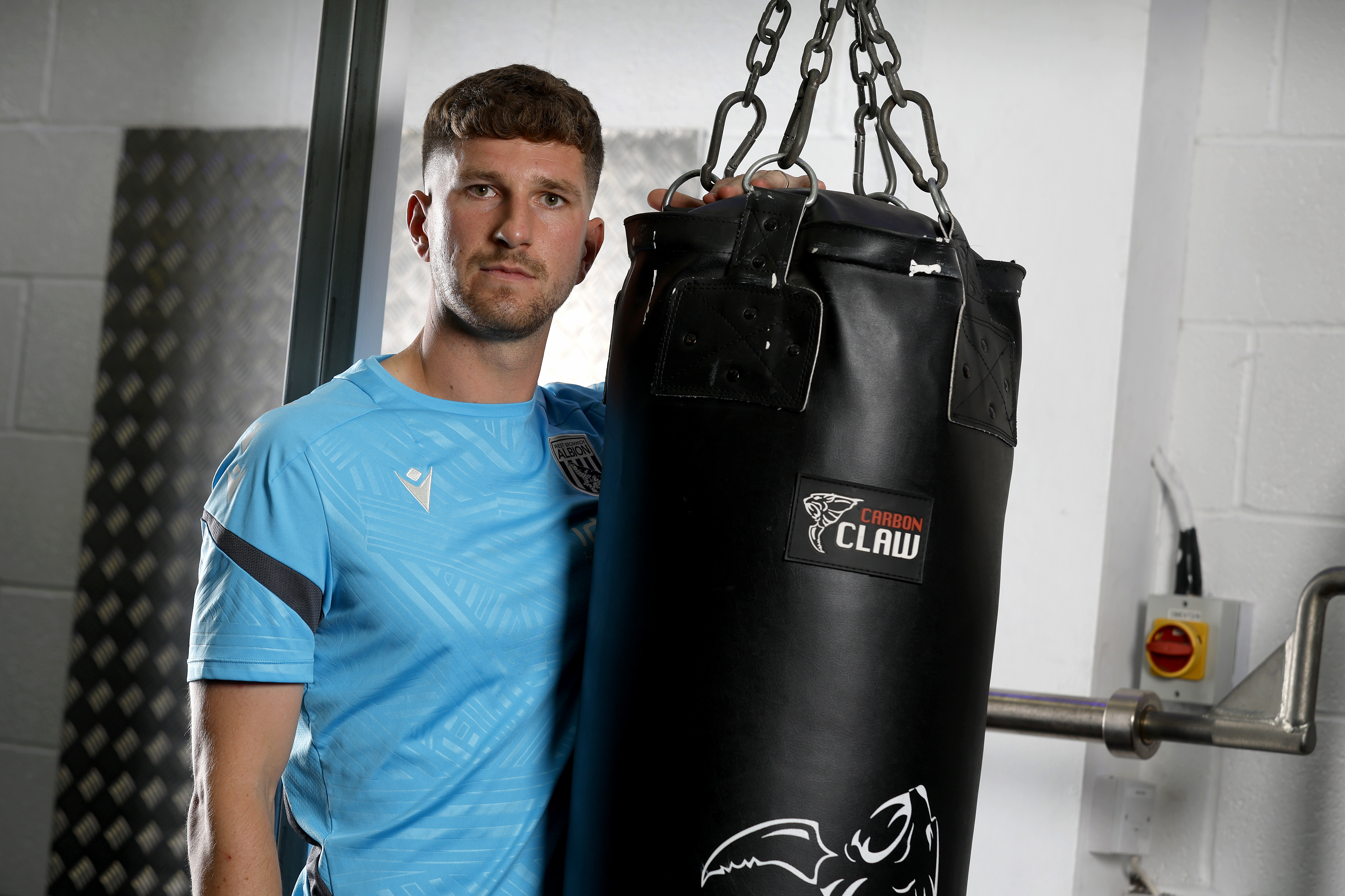 Chris Mepham leaning on a punch bag in the gym looking at the camera