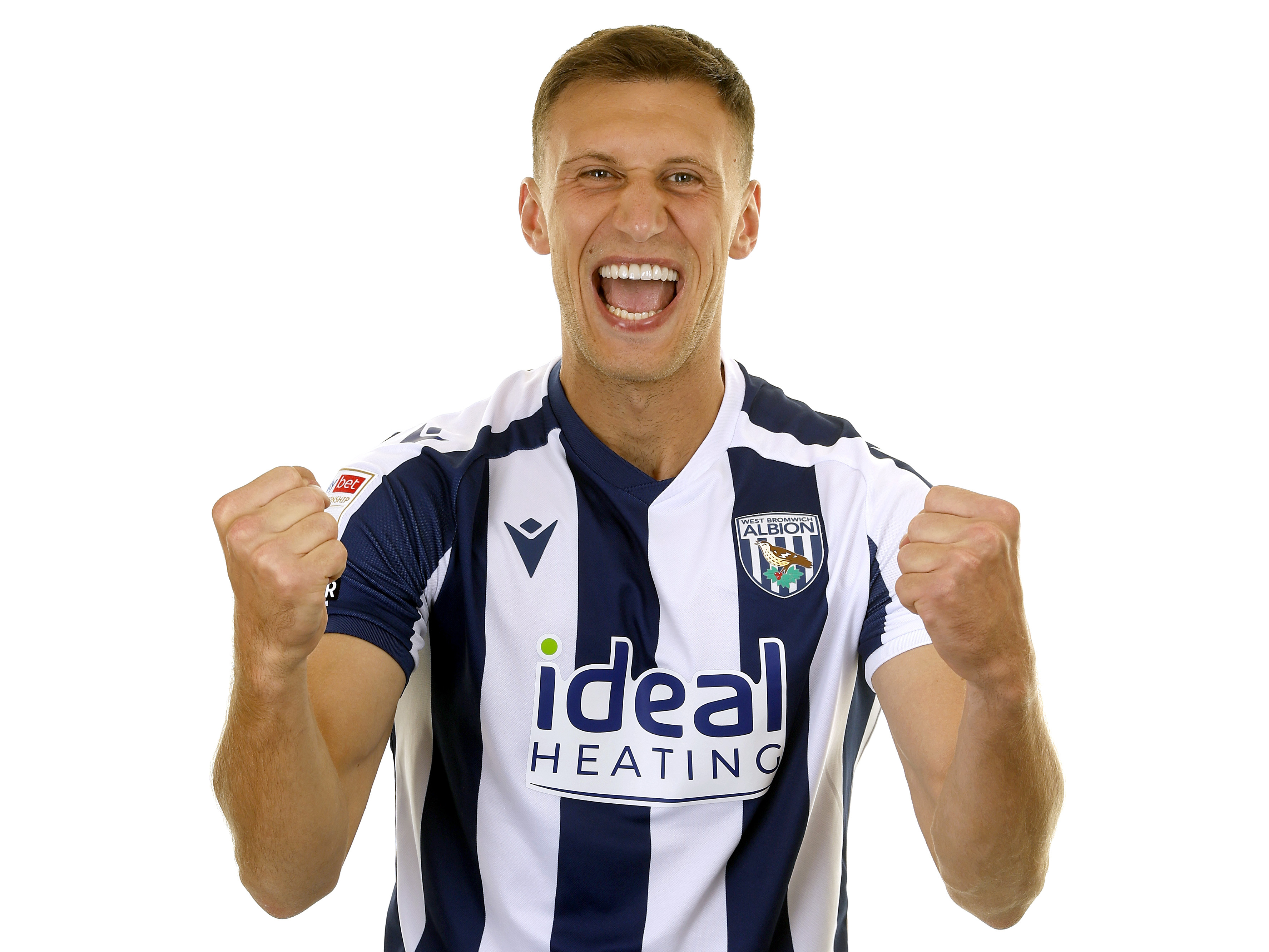 Krystian Bielik celebrating to the camera while stood in a home shirt 