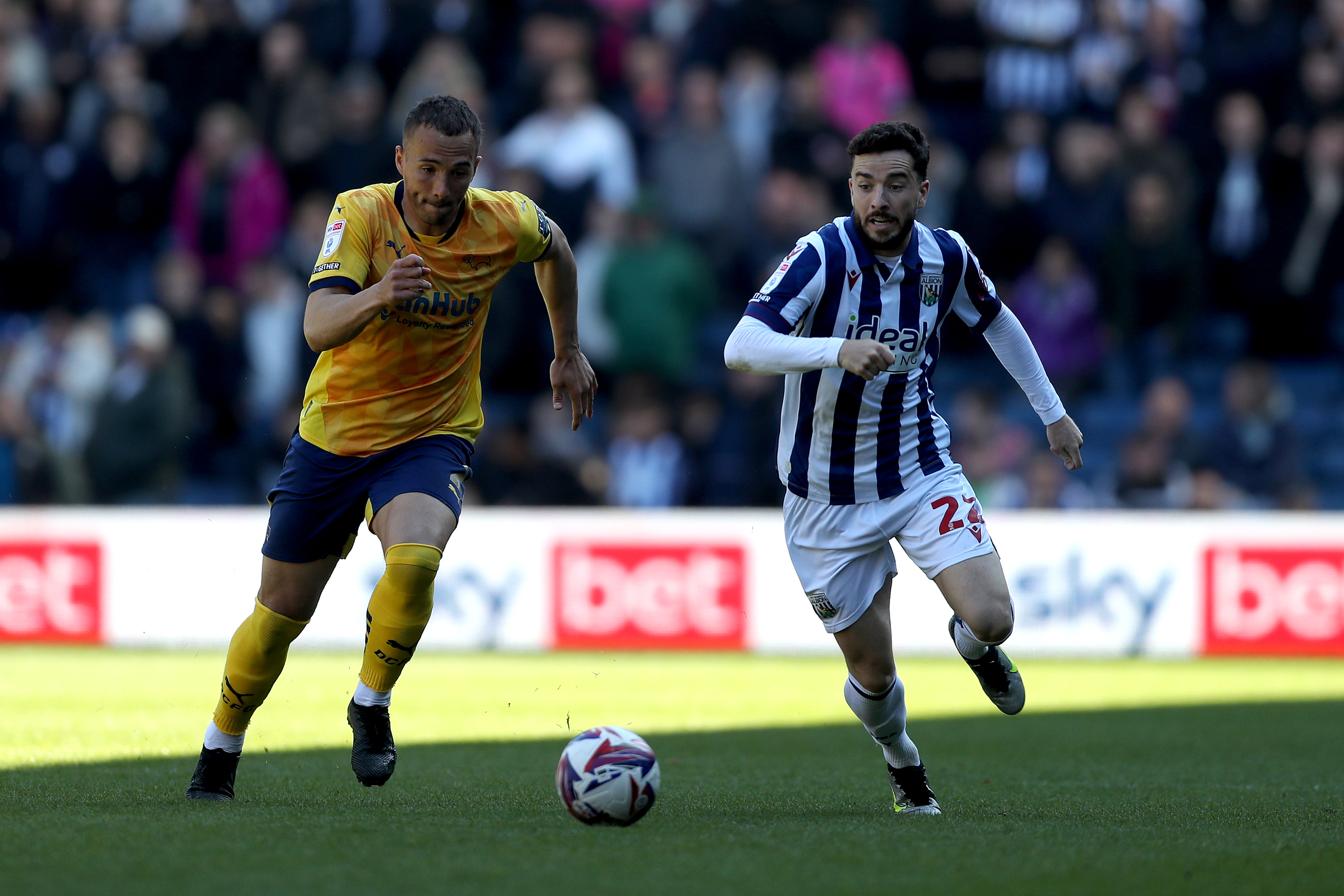 Mikey Johnston races to the ball with Kane Wilson at The Hawthorns during a clash between Albion and Derby