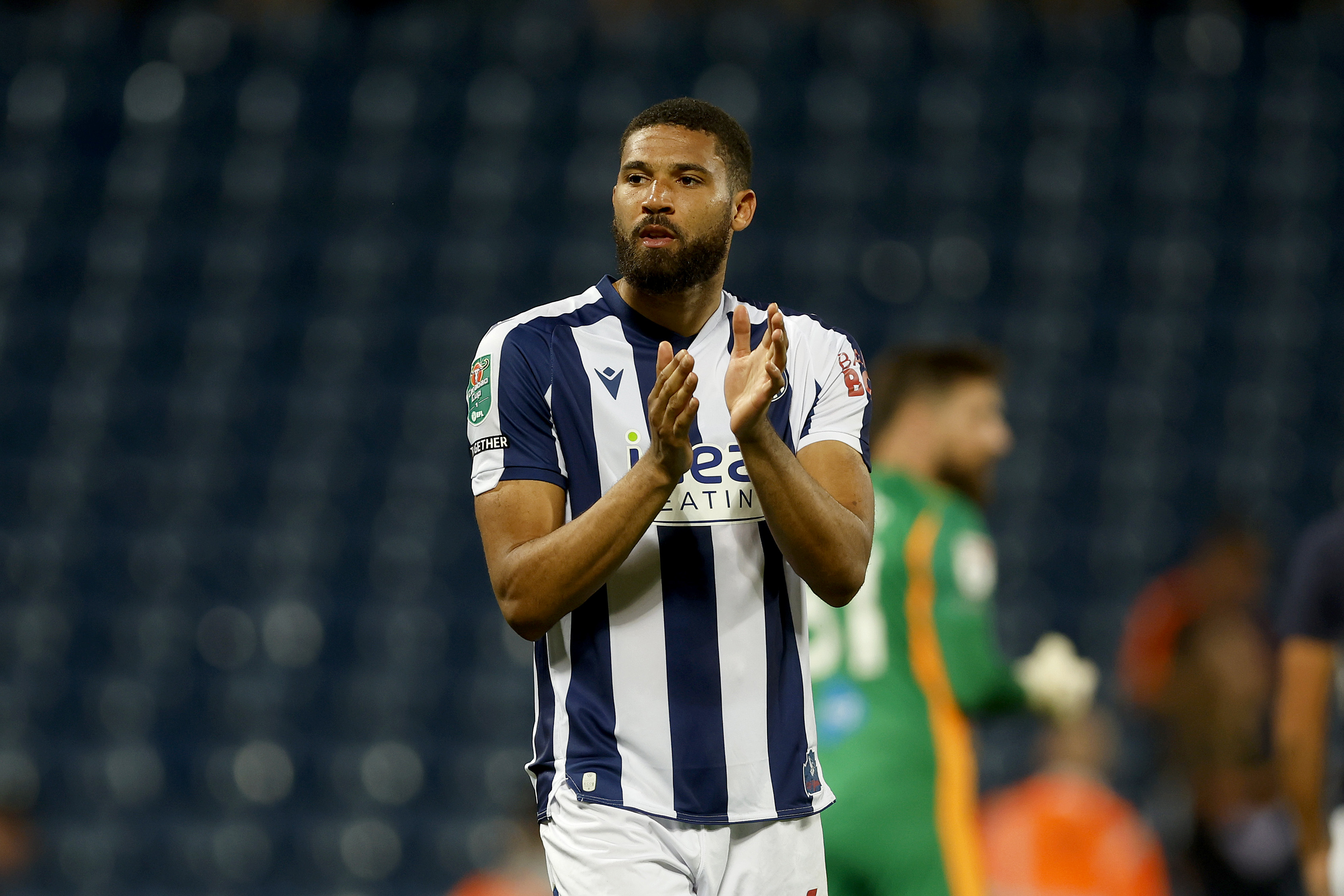 George Campbell applauding WBA fans after a game while wearing home kit