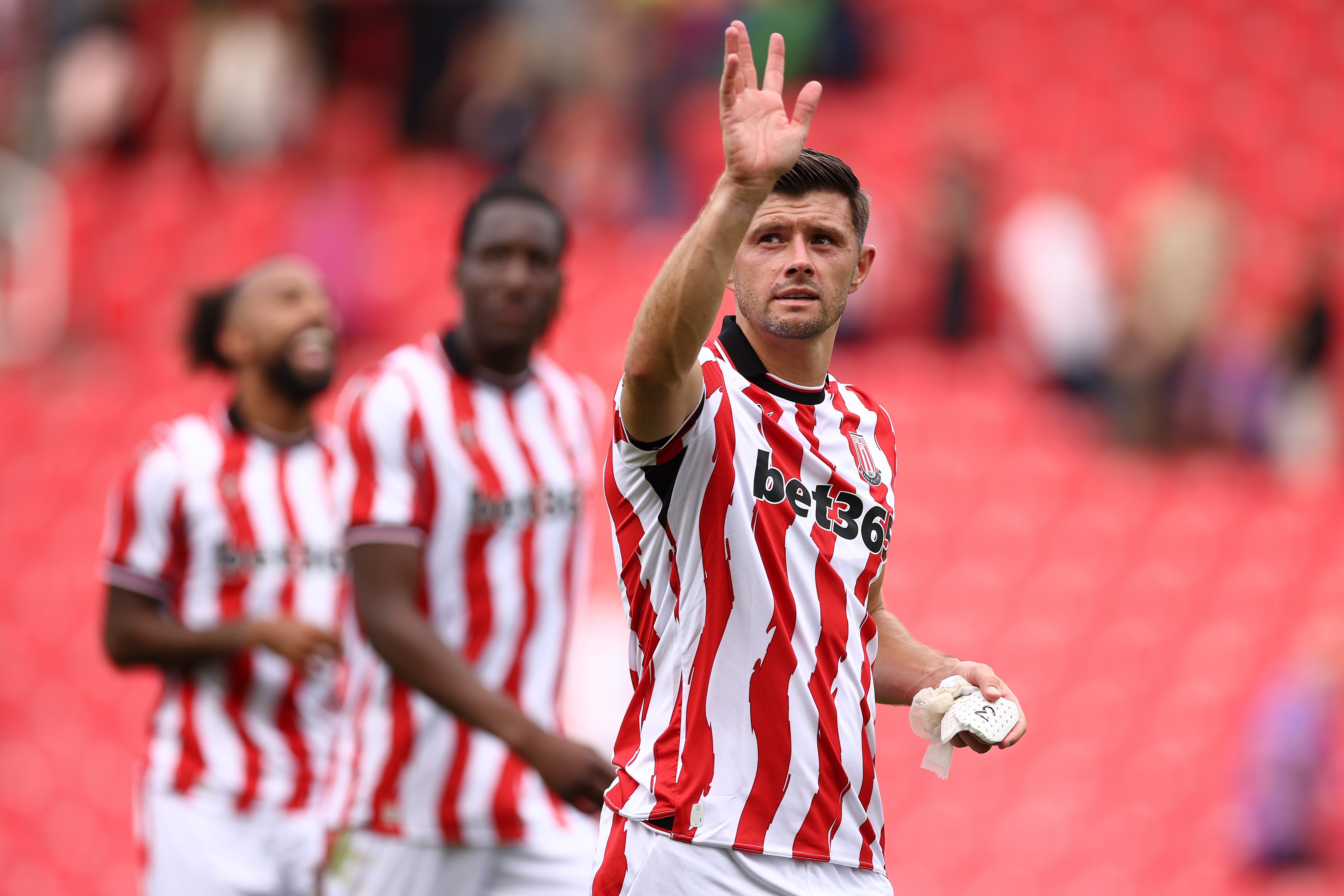 Stoke City's Aaron Cresswell waving at fans while in a Stoke home shirt