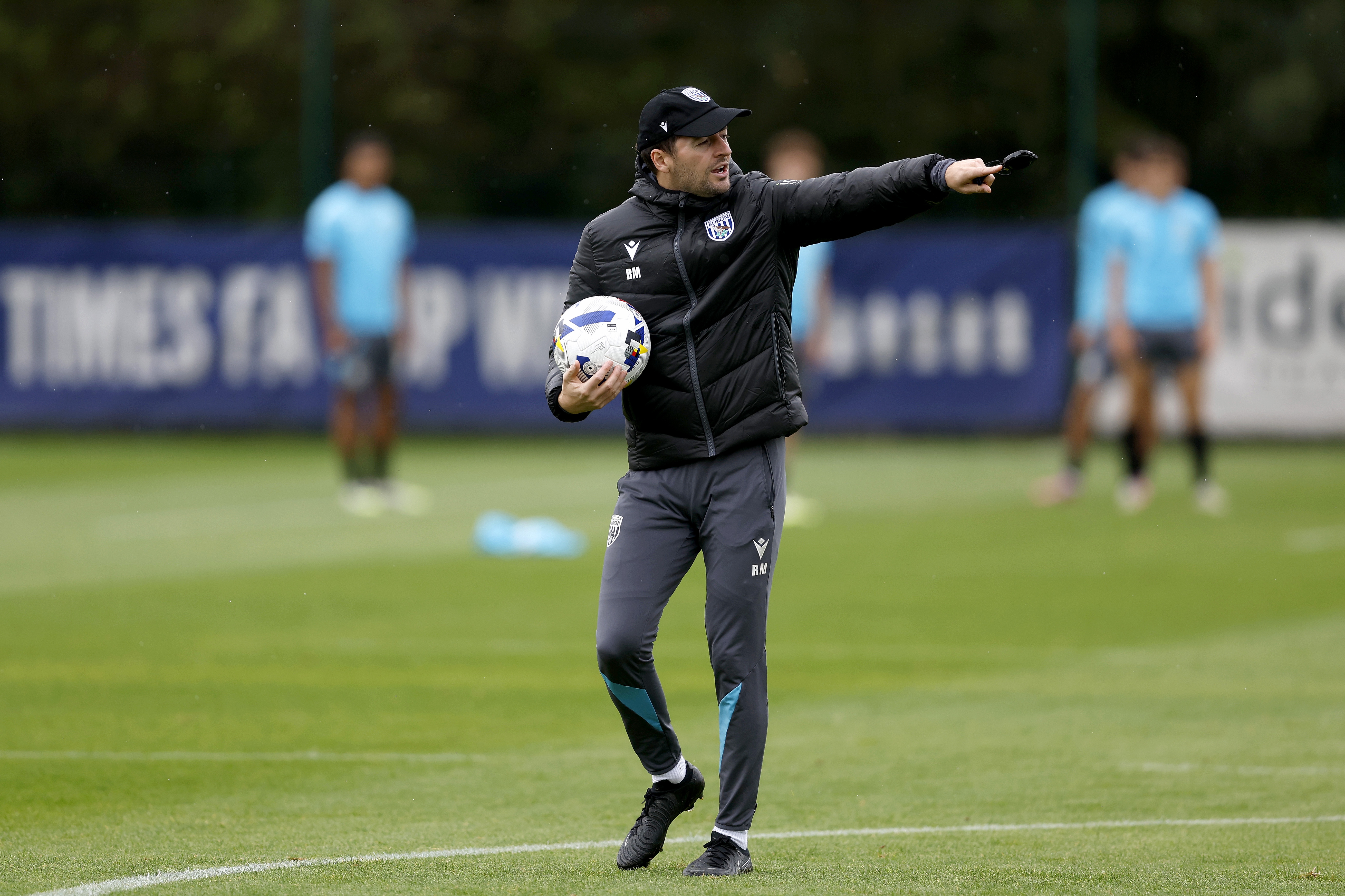 Ryan Mason with a cap on and a stopwatch in training