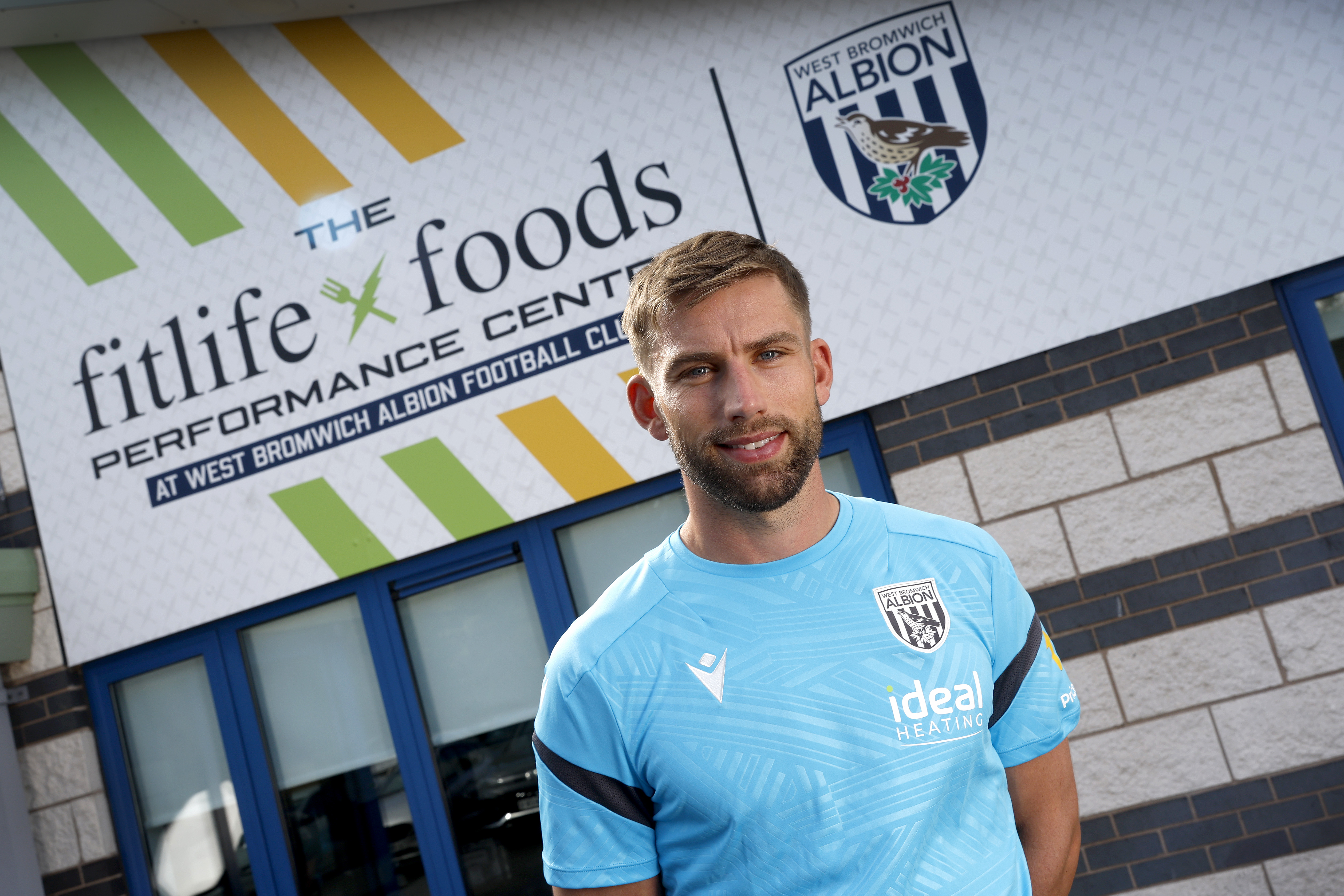 Charlie Taylor smiling at the camera while stood outside the front of the training ground 