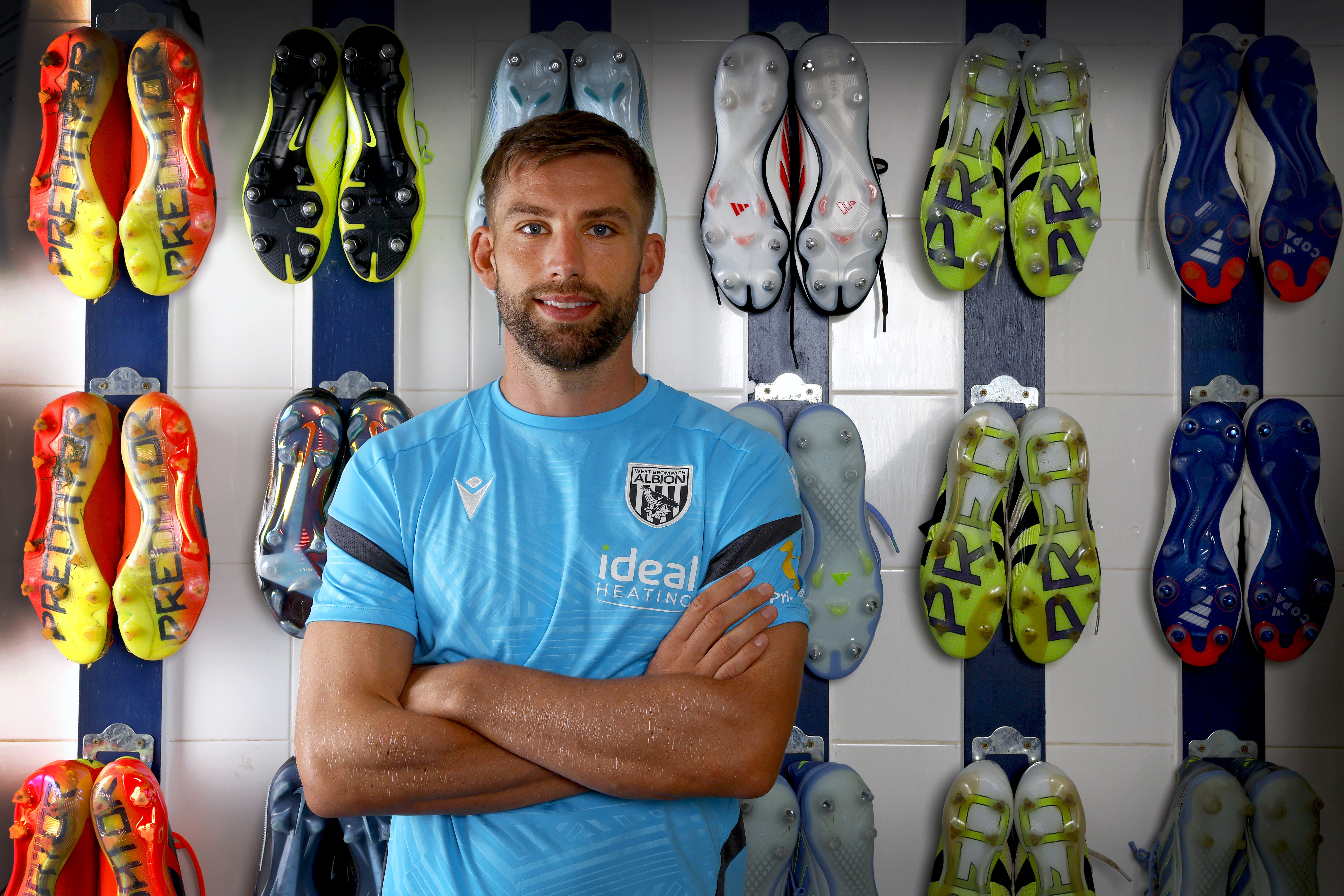 Charlie Taylor smiling at the camera while stood in the boot room
