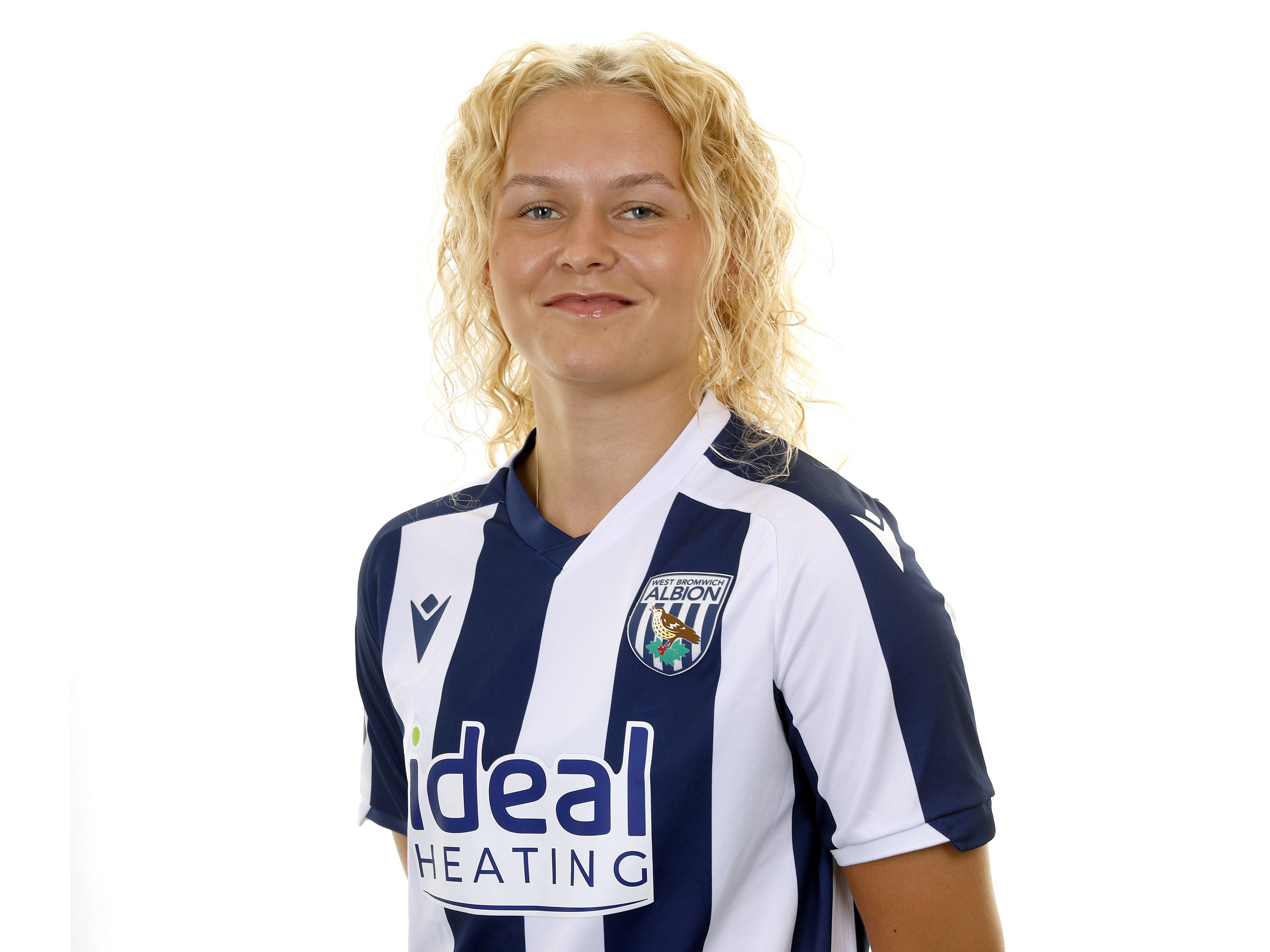 Marli Rhodes smiling at the camera while in the home kit 