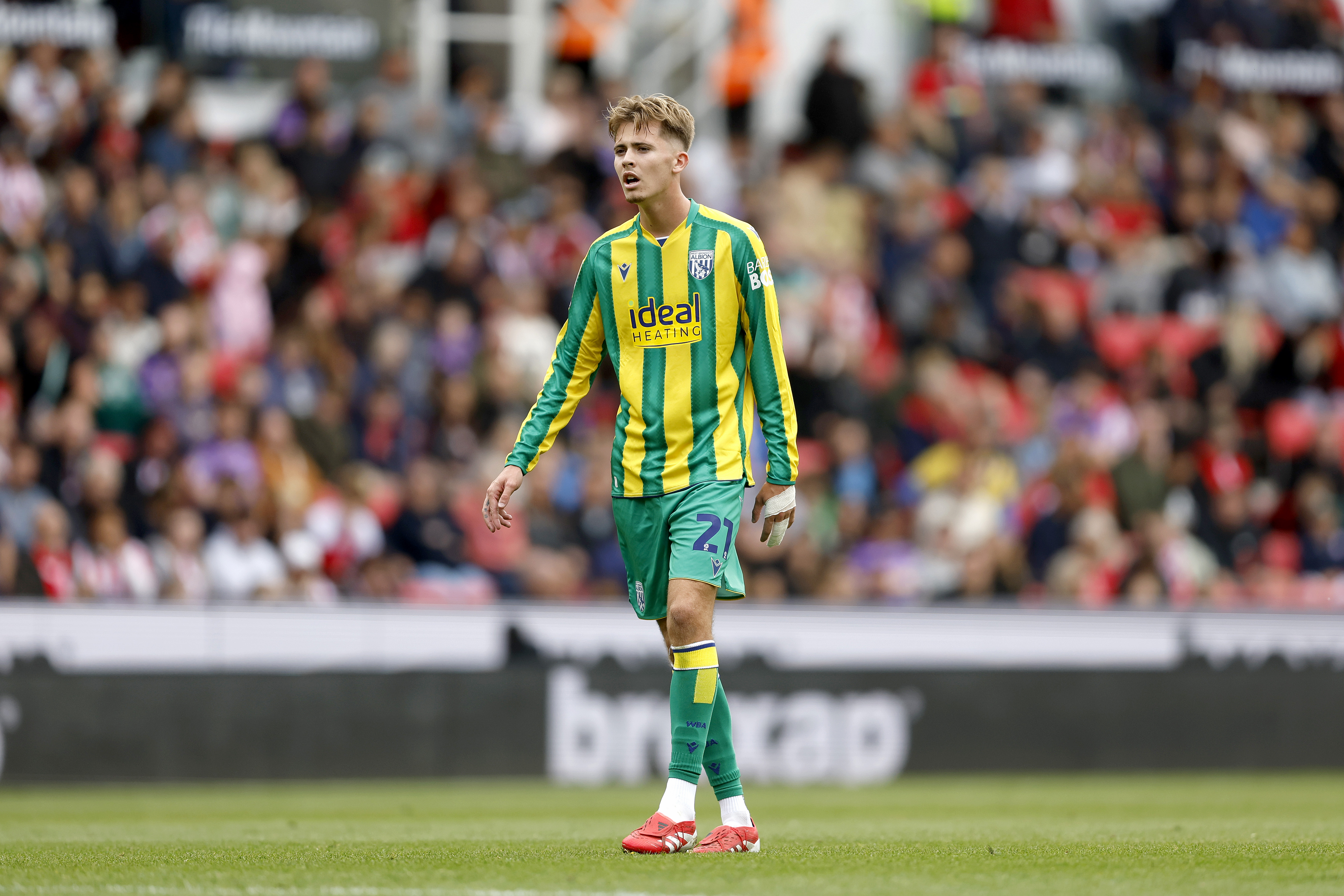Isaac Price in action in the yellow and green away kit 