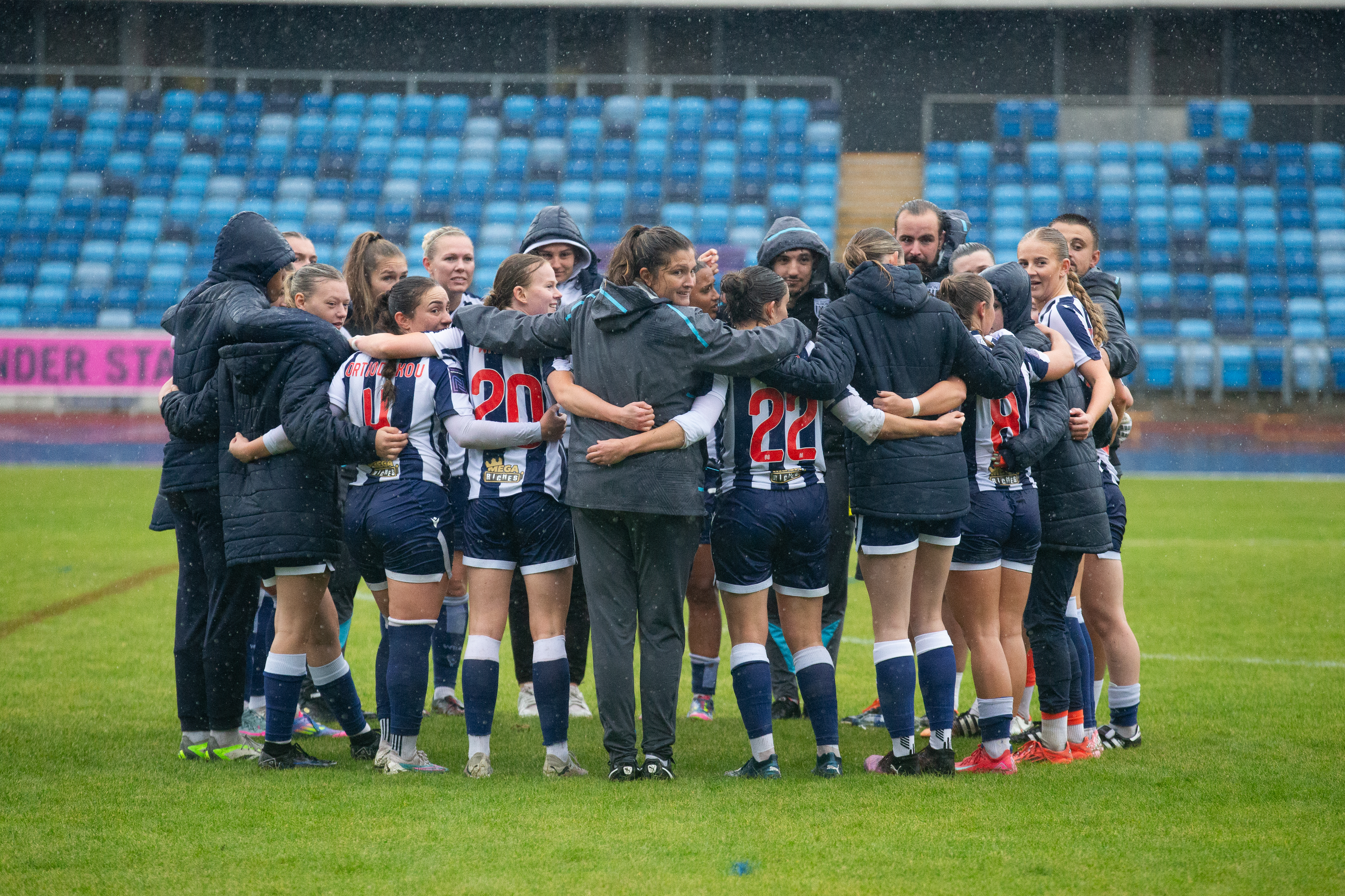 Albion Women players and staff in a team huddle after a game