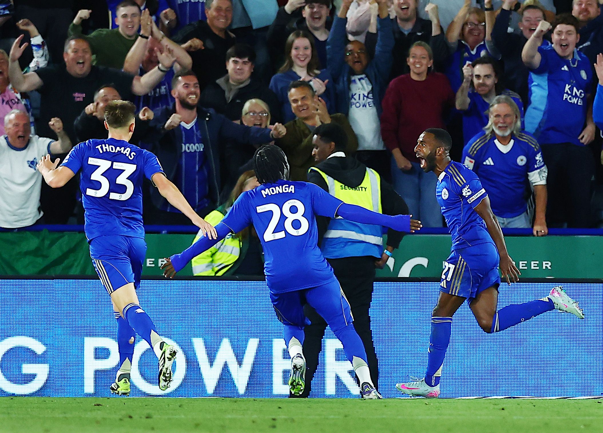 Three Leicester City players celebrate a goal scored in their home kit 