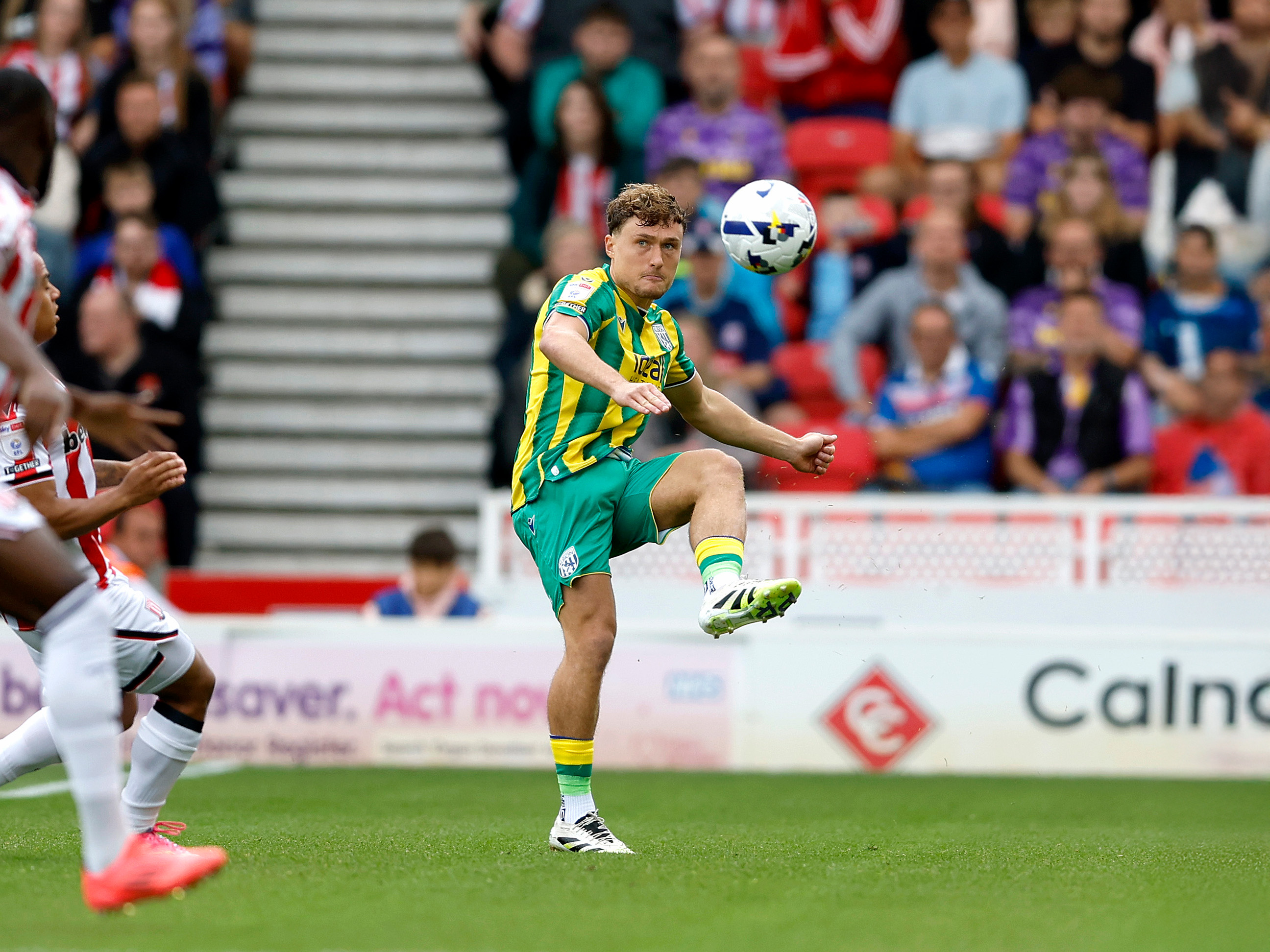 A photo of Albion defender Callum Styles in the green and yellow 2025/26 away kit