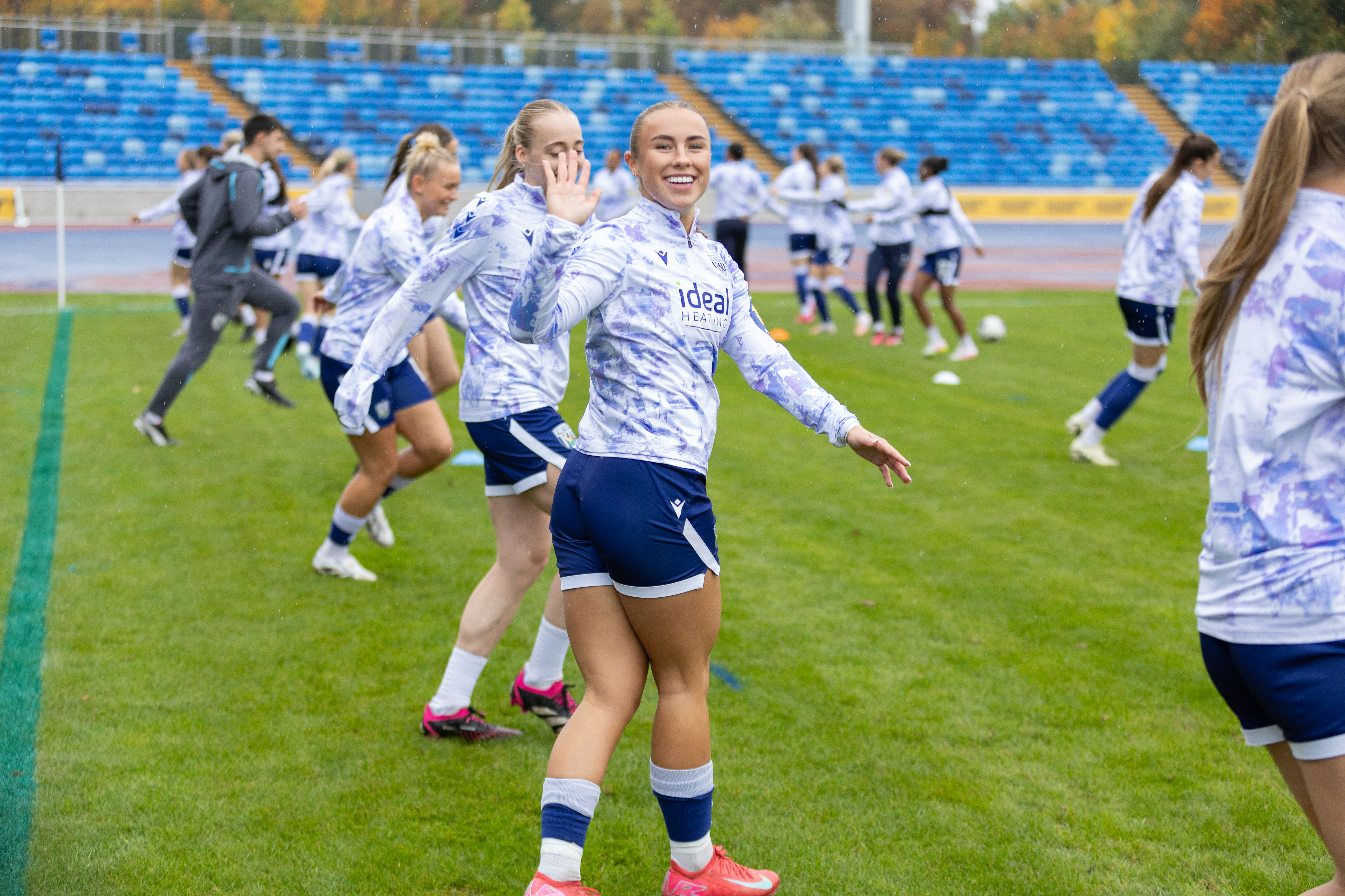 Seren Watkins smiling at the camera while warming up before a game