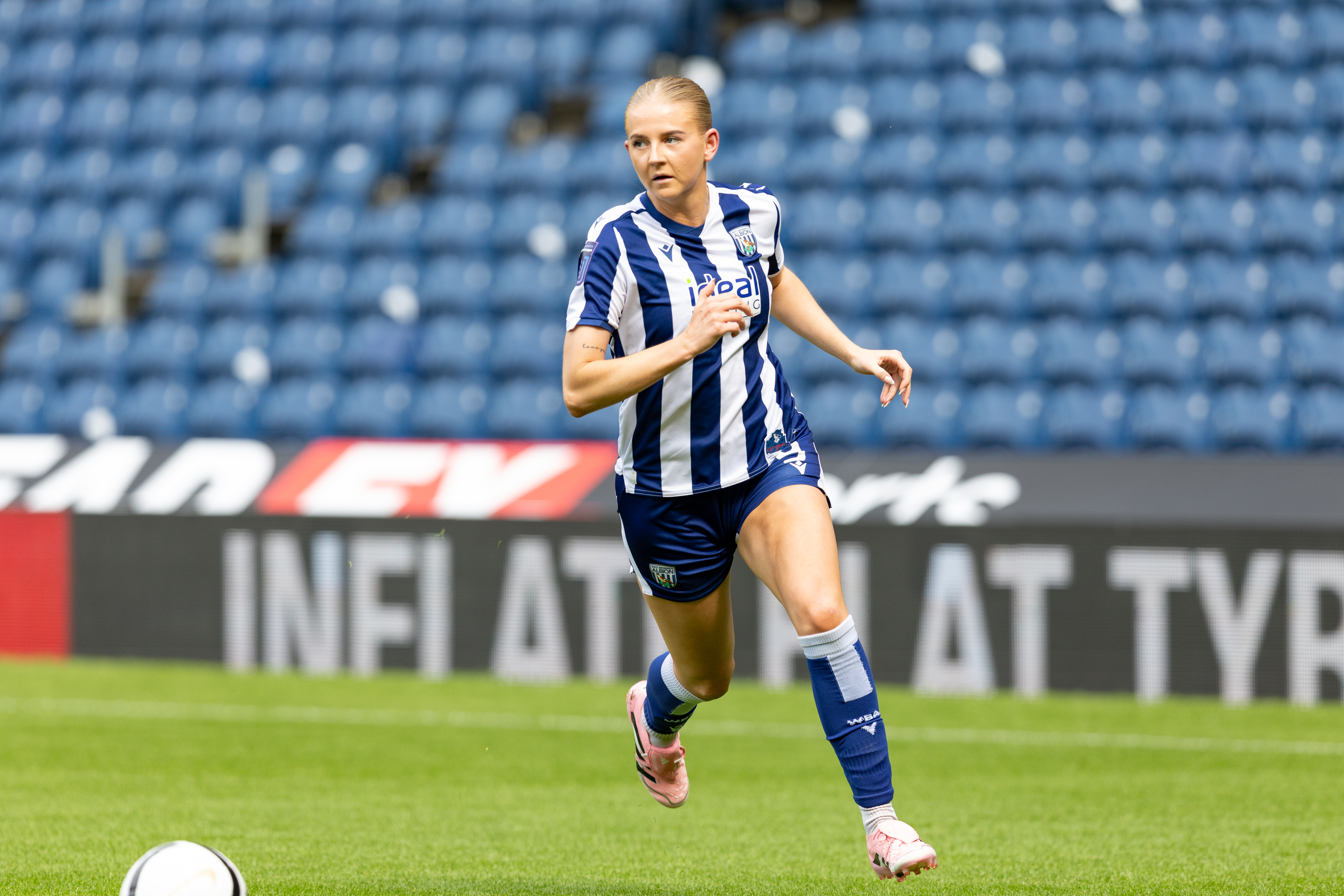 Rhianne Oakley running with the ball in the home kit