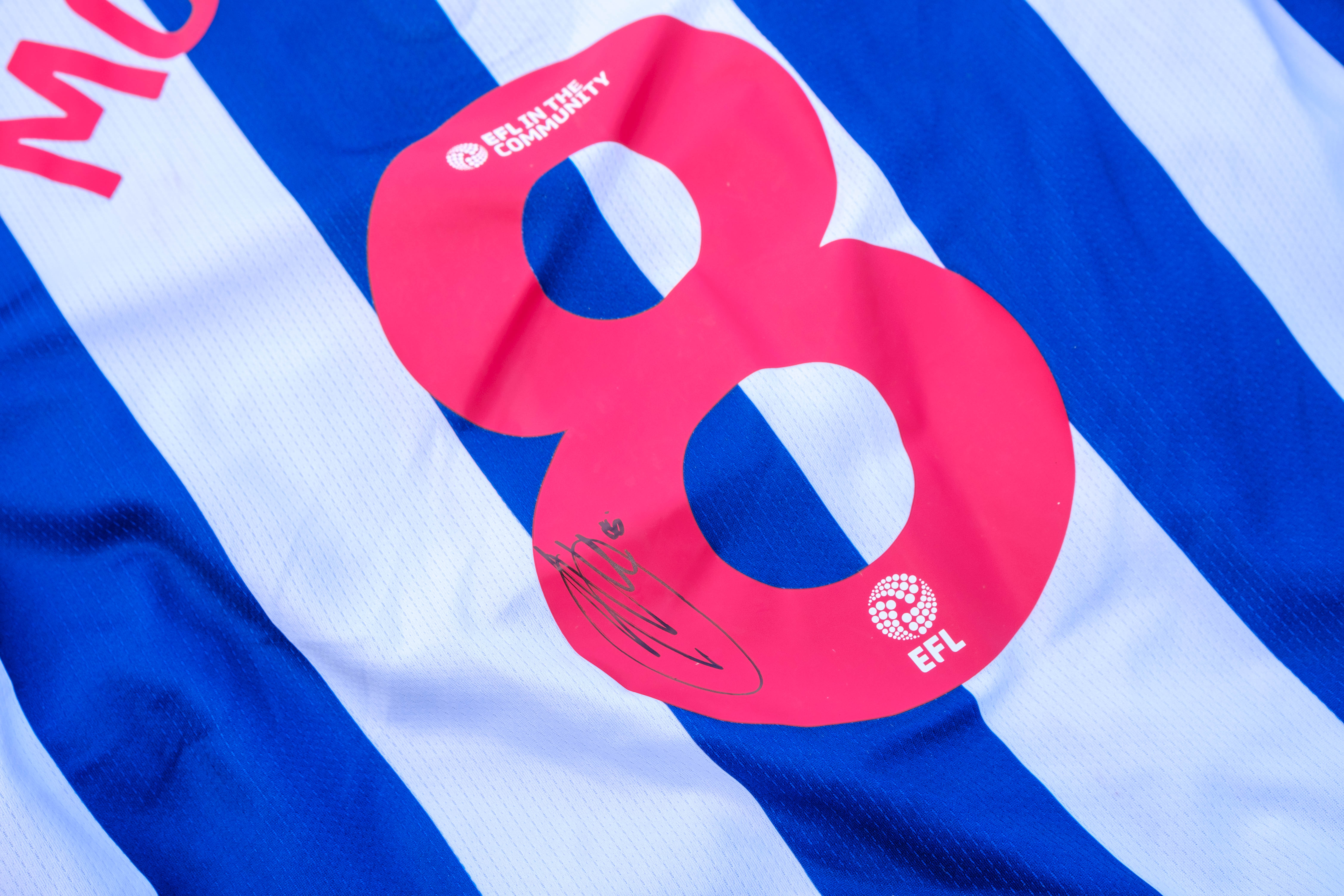 Close-up of Molumby's signature on his shirt.