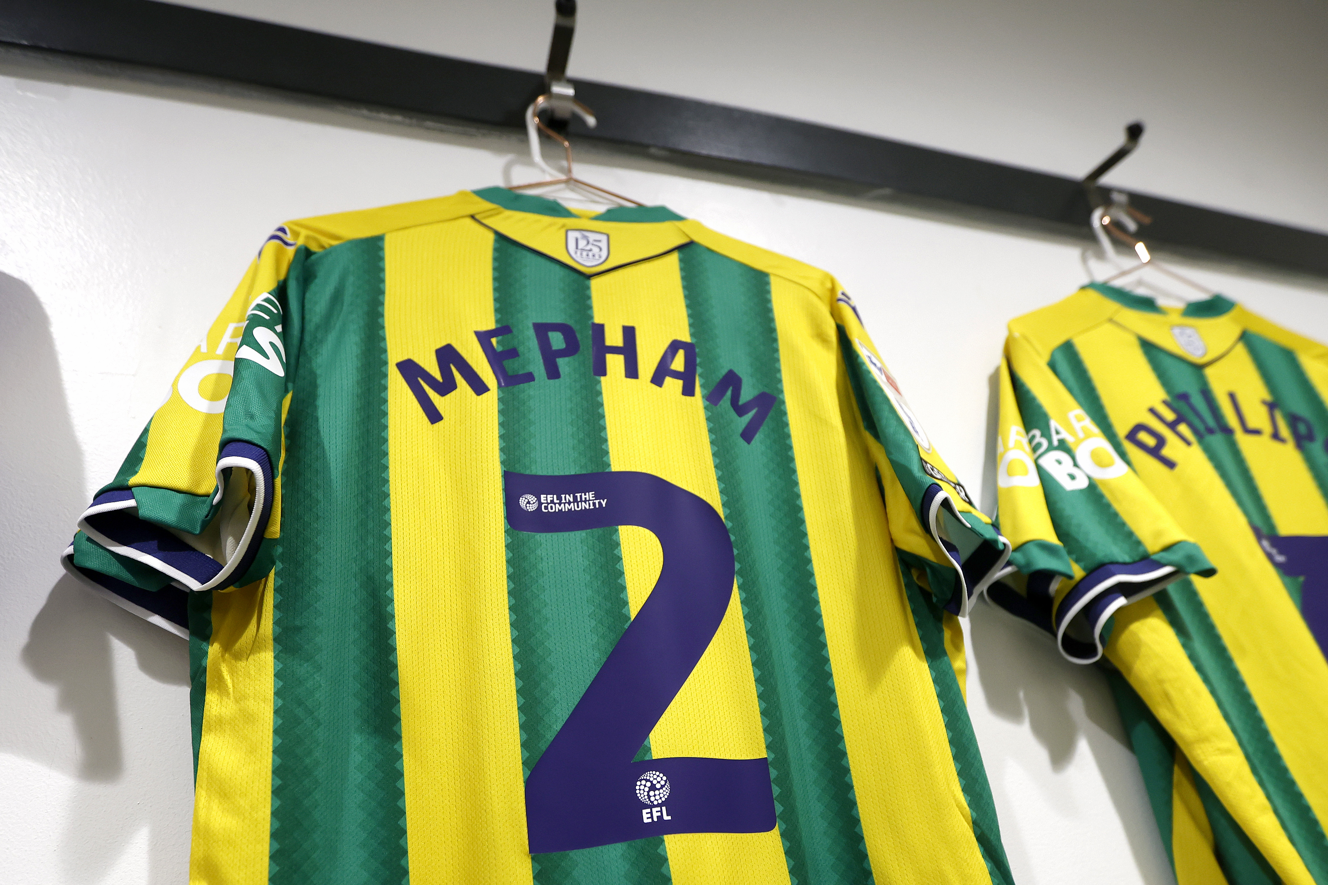 The back of Chris Mepham's green and yellow away shirt hanging in the dressing room with his name and number 2 on display