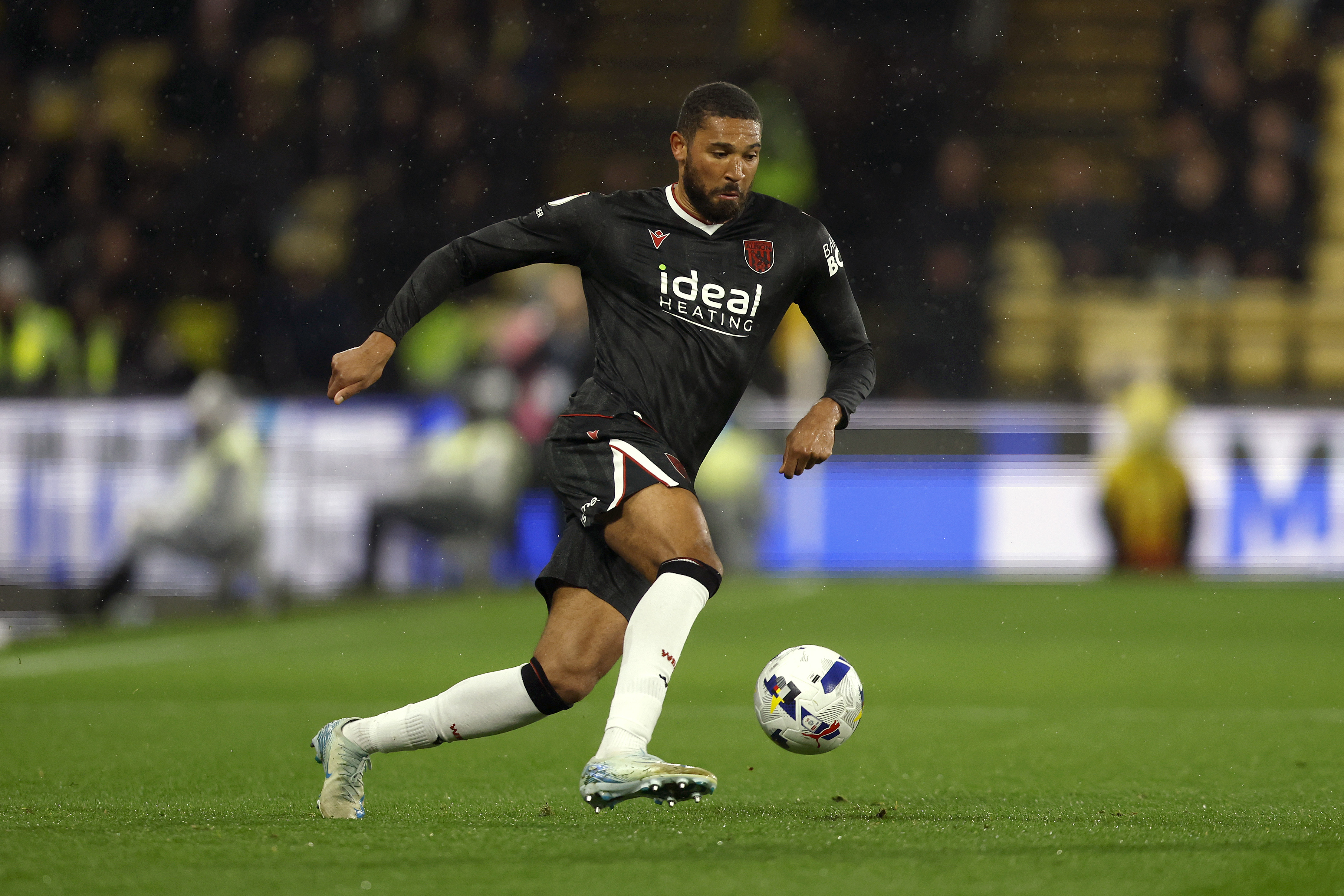 George Campbell on the ball during a game while wearing the black away kit