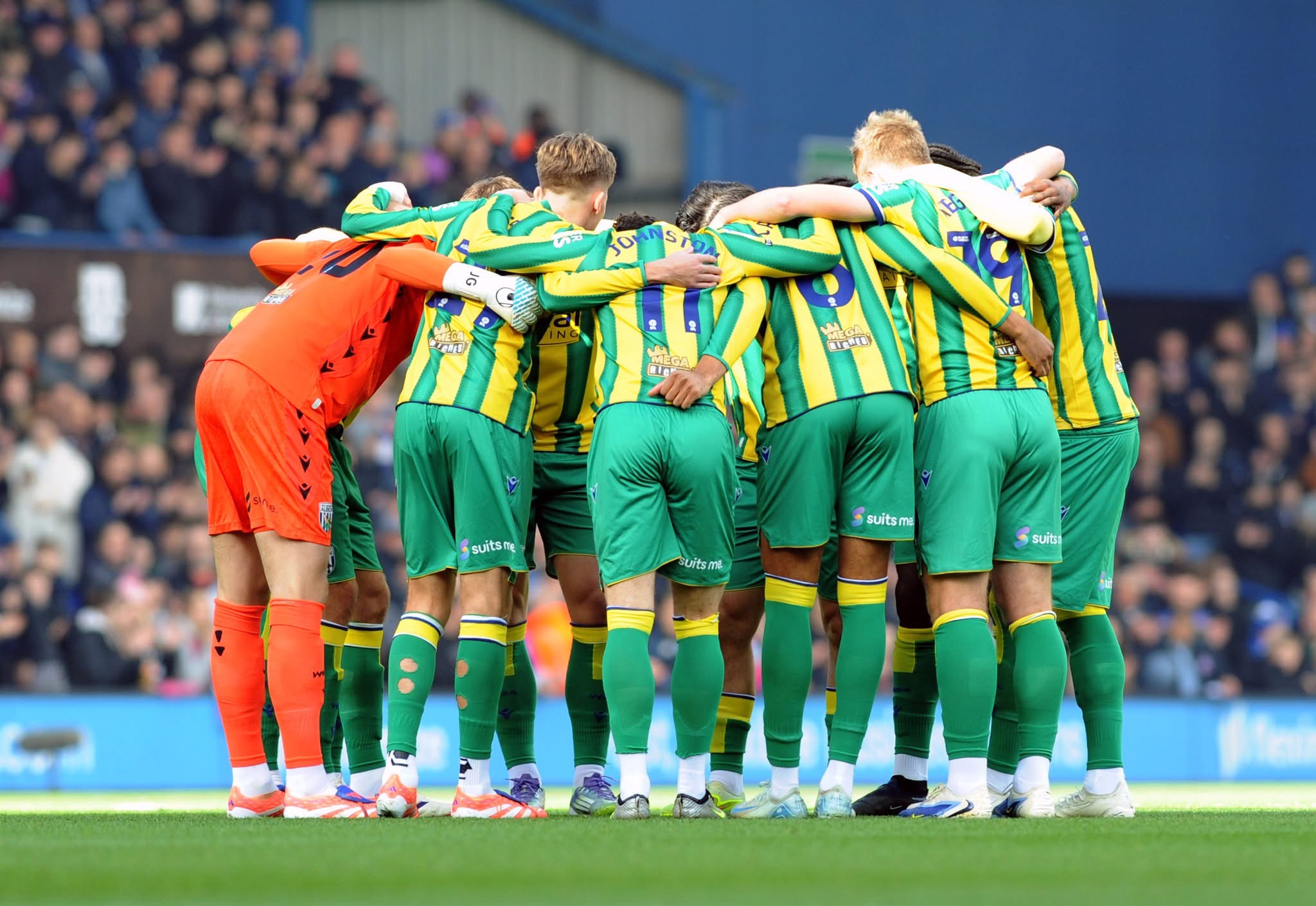 WBA's pre-match team huddle in green and yellow colours