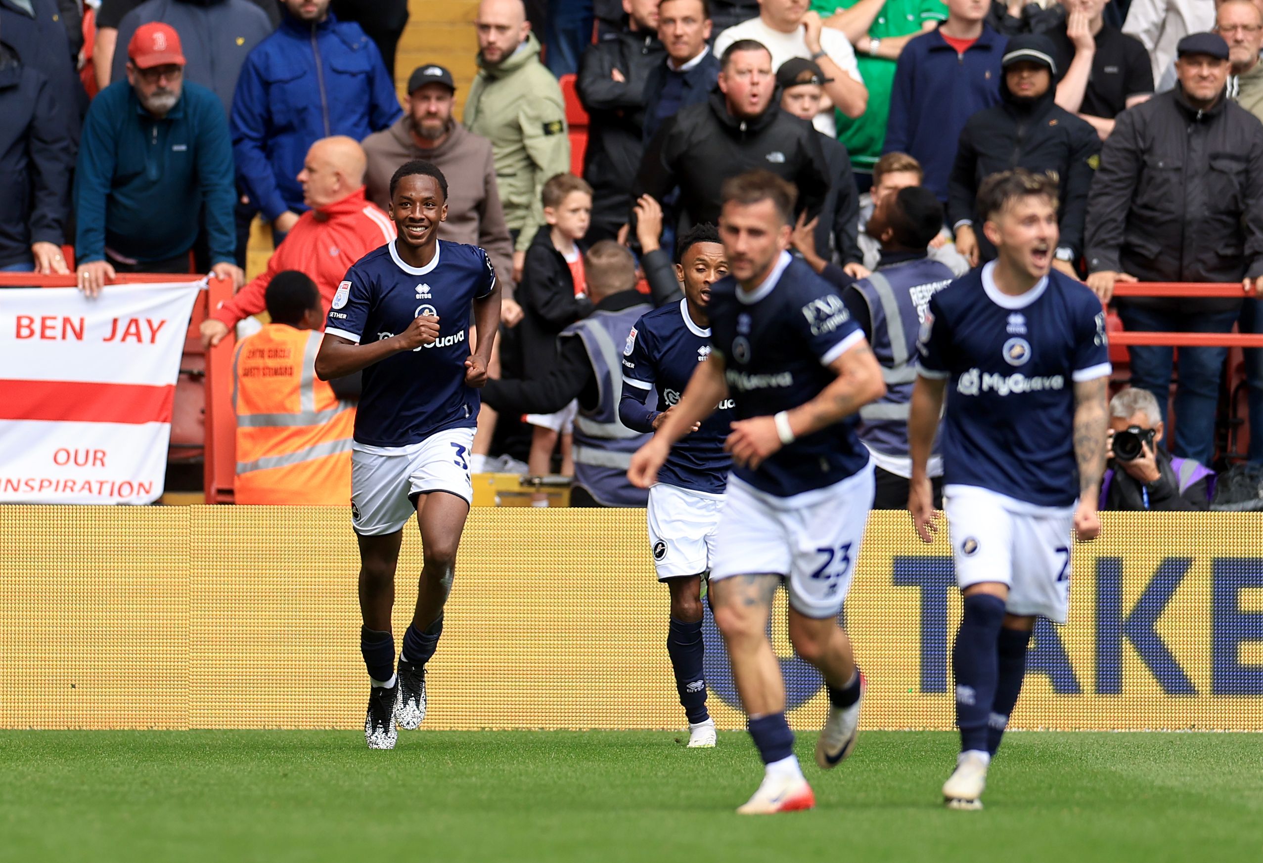 Millwall players in the home kit celebrating a goal