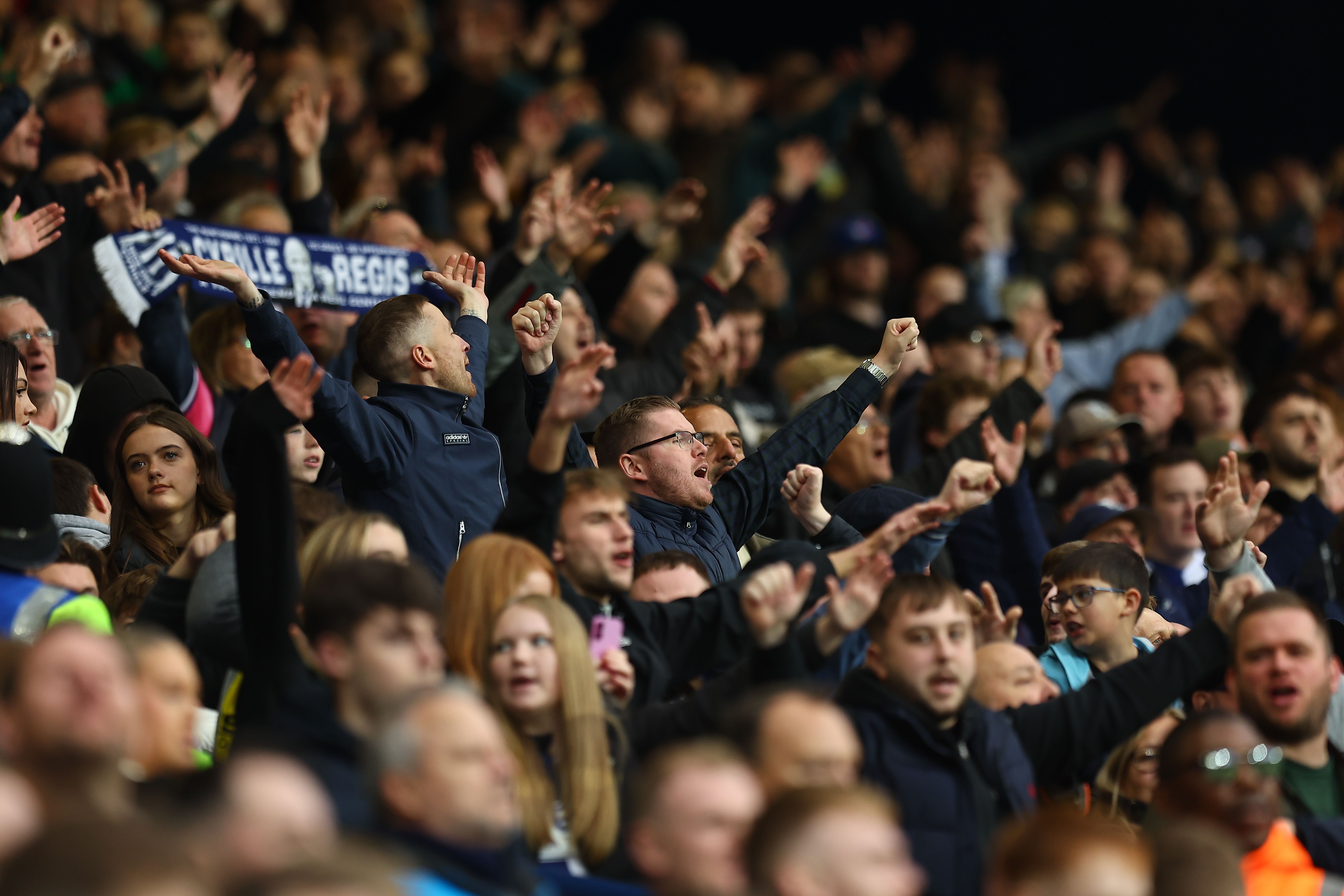 A general view of several WBA fans cheering at a game
