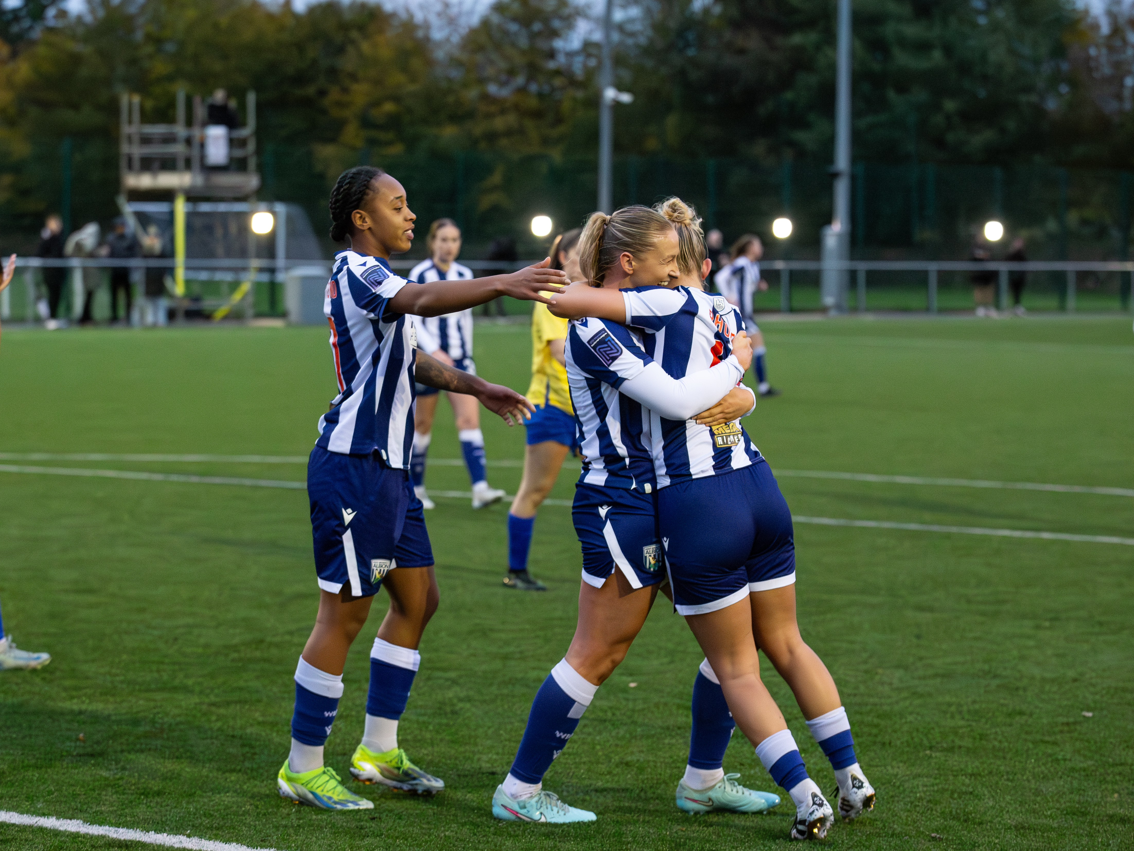 A photo of the women's team celebrating a goal. 