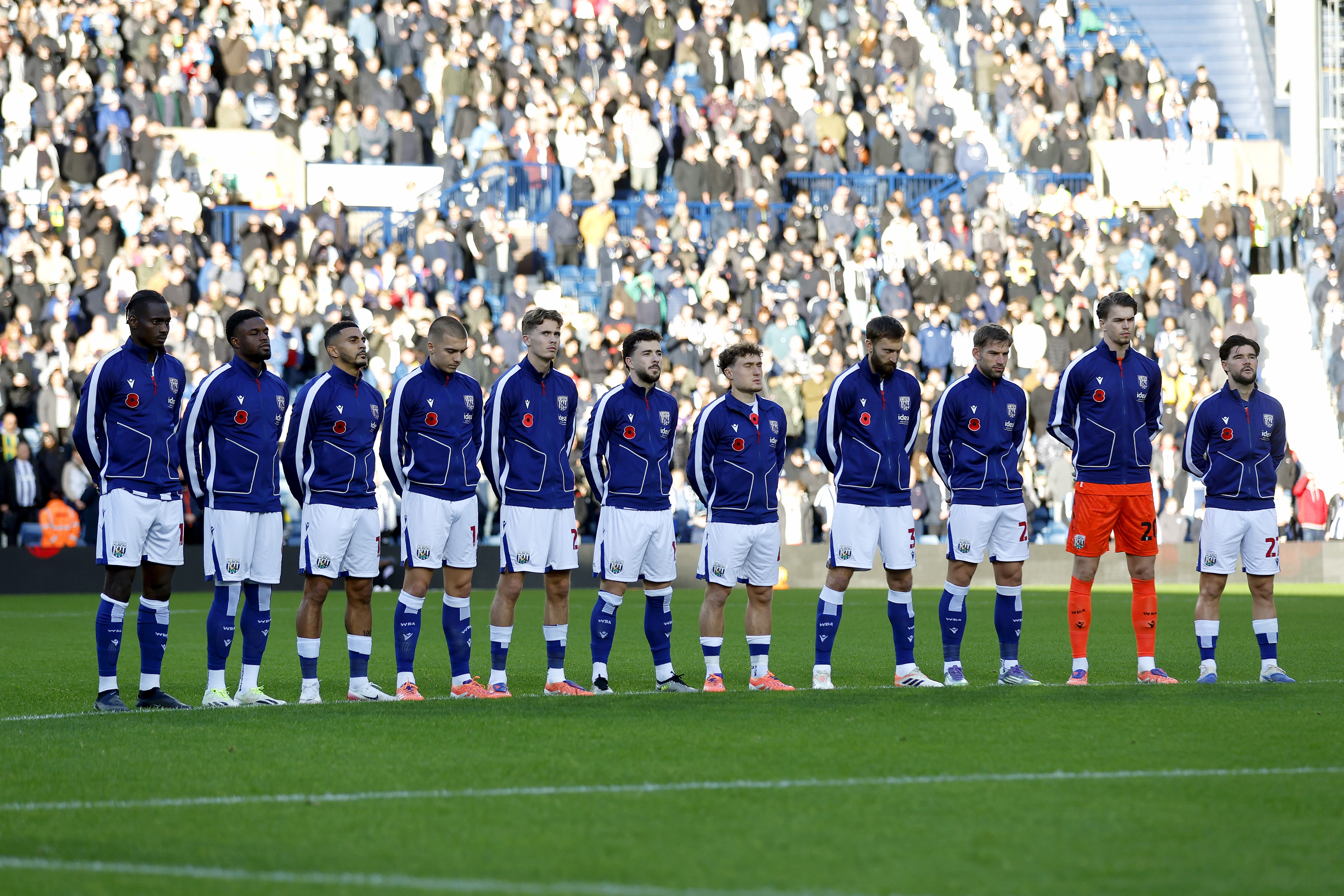 Albion's starting XI observe a period of silence before the game against Oxford on the pitch 