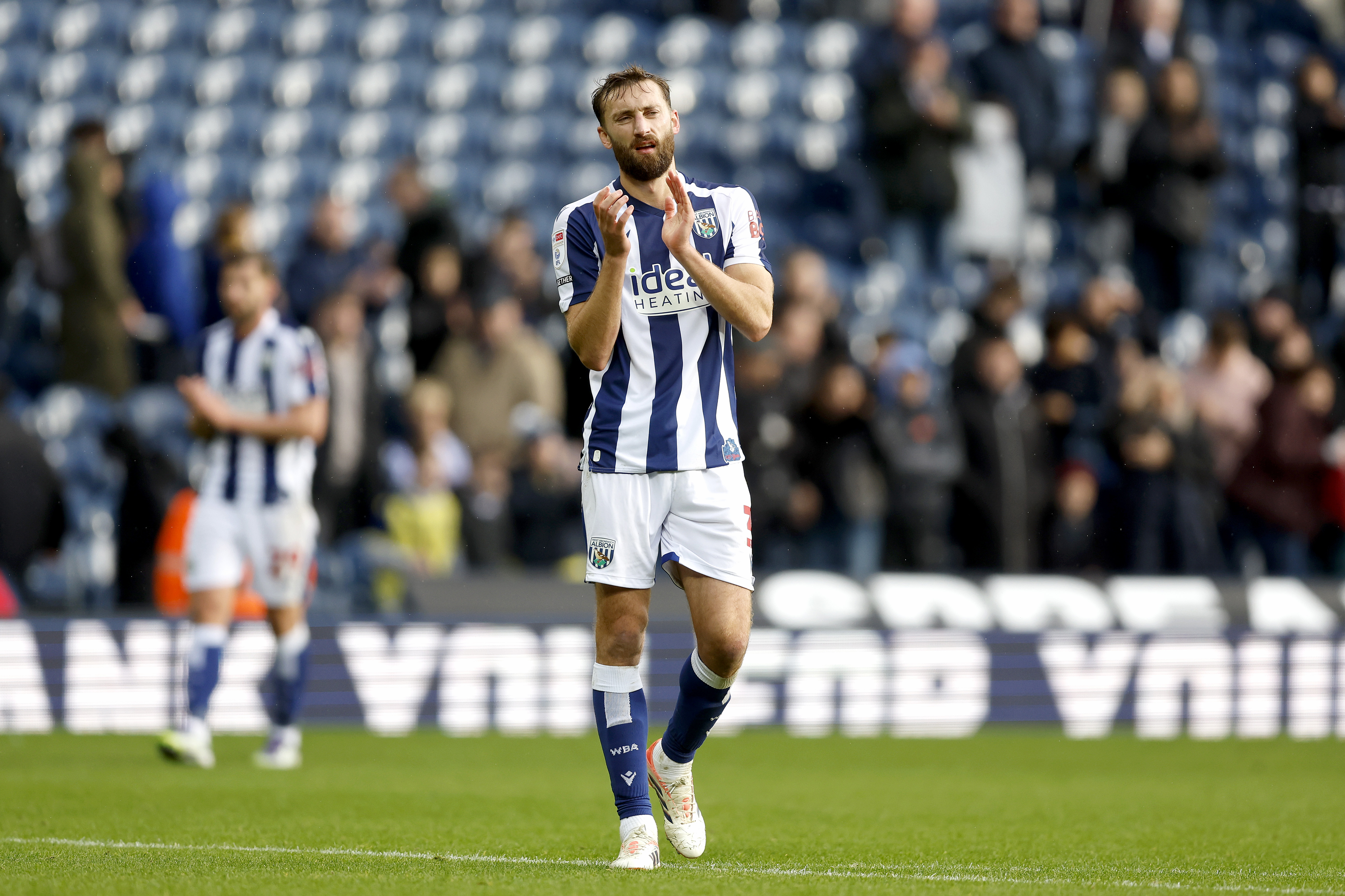 Nat Phillips applauding WBA fans while in a home shirt 