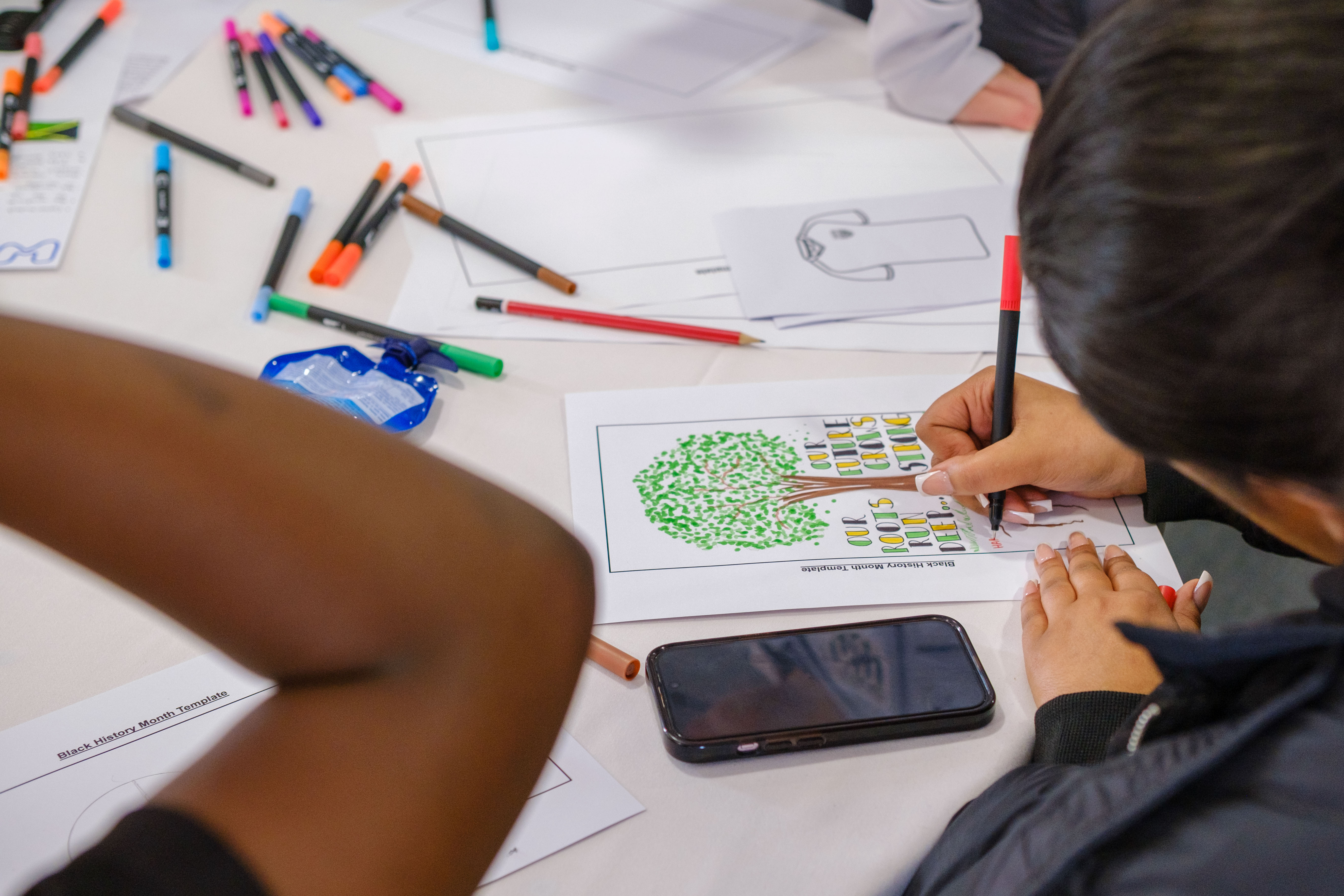 A pupil designing a poster, which will be displayed on the big screen at a Hawthorns fixture.