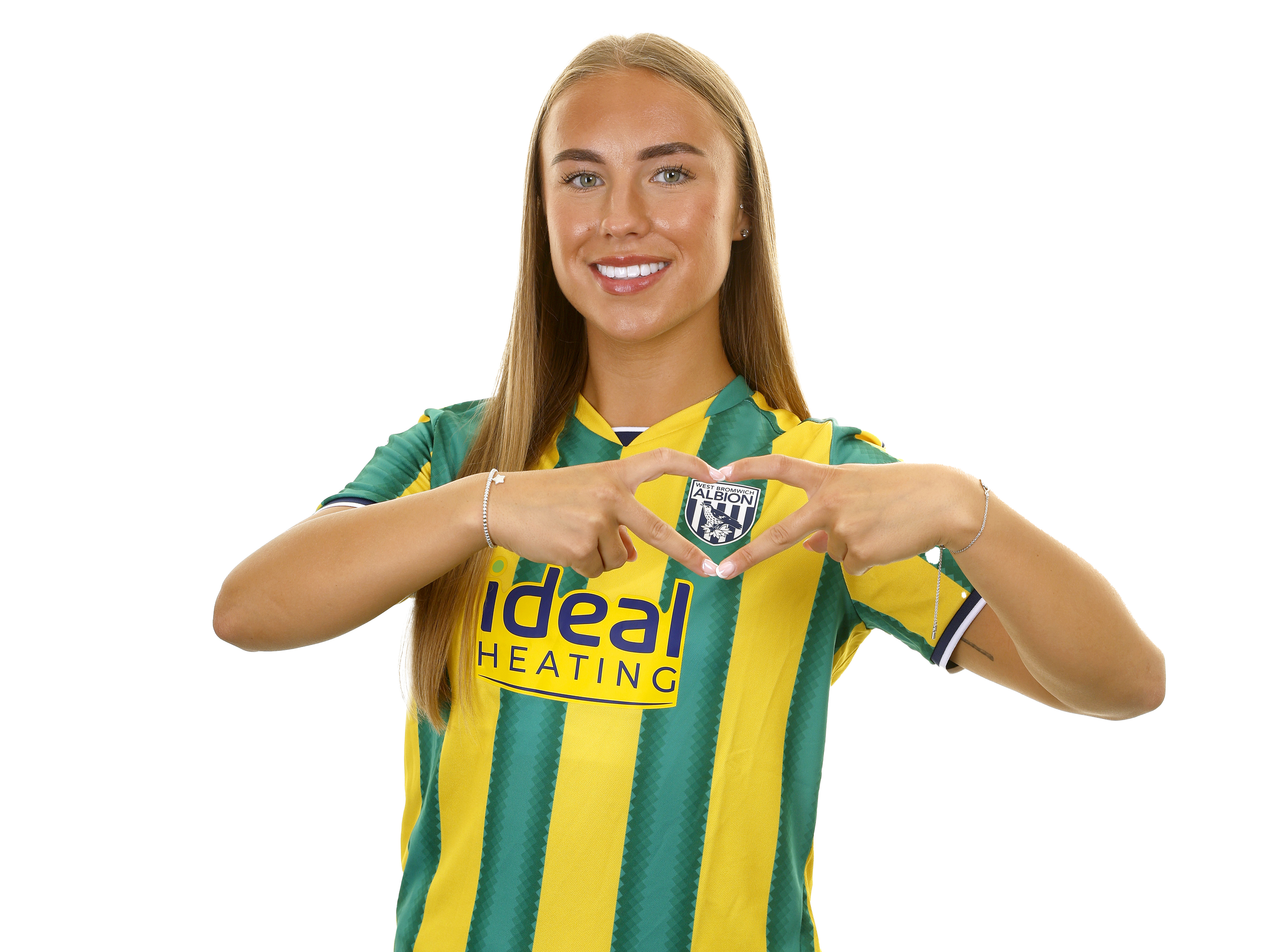 Seren Watkins smiling at the camera while wearing the green and yellow away kit 