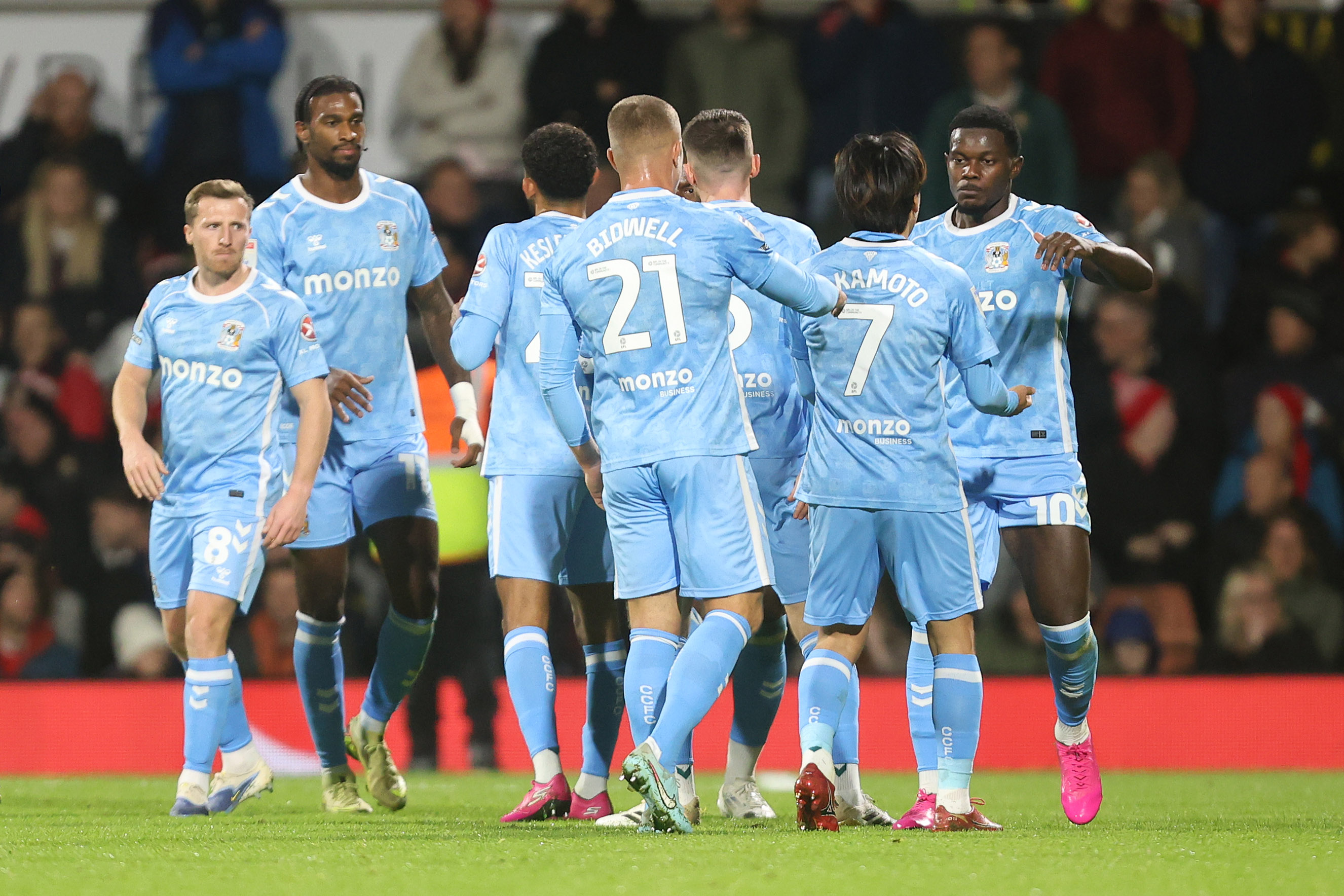 Several Coventry players in their home kit celebrate a goal
