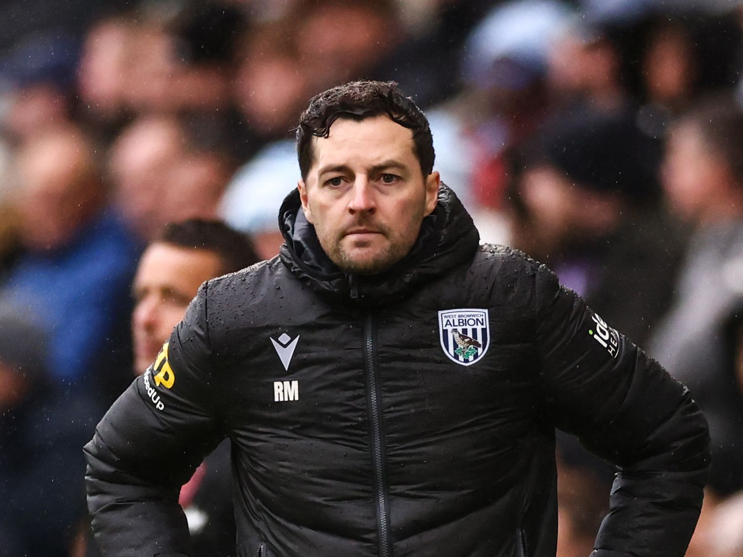 Ryan Mason in a black coat during a game