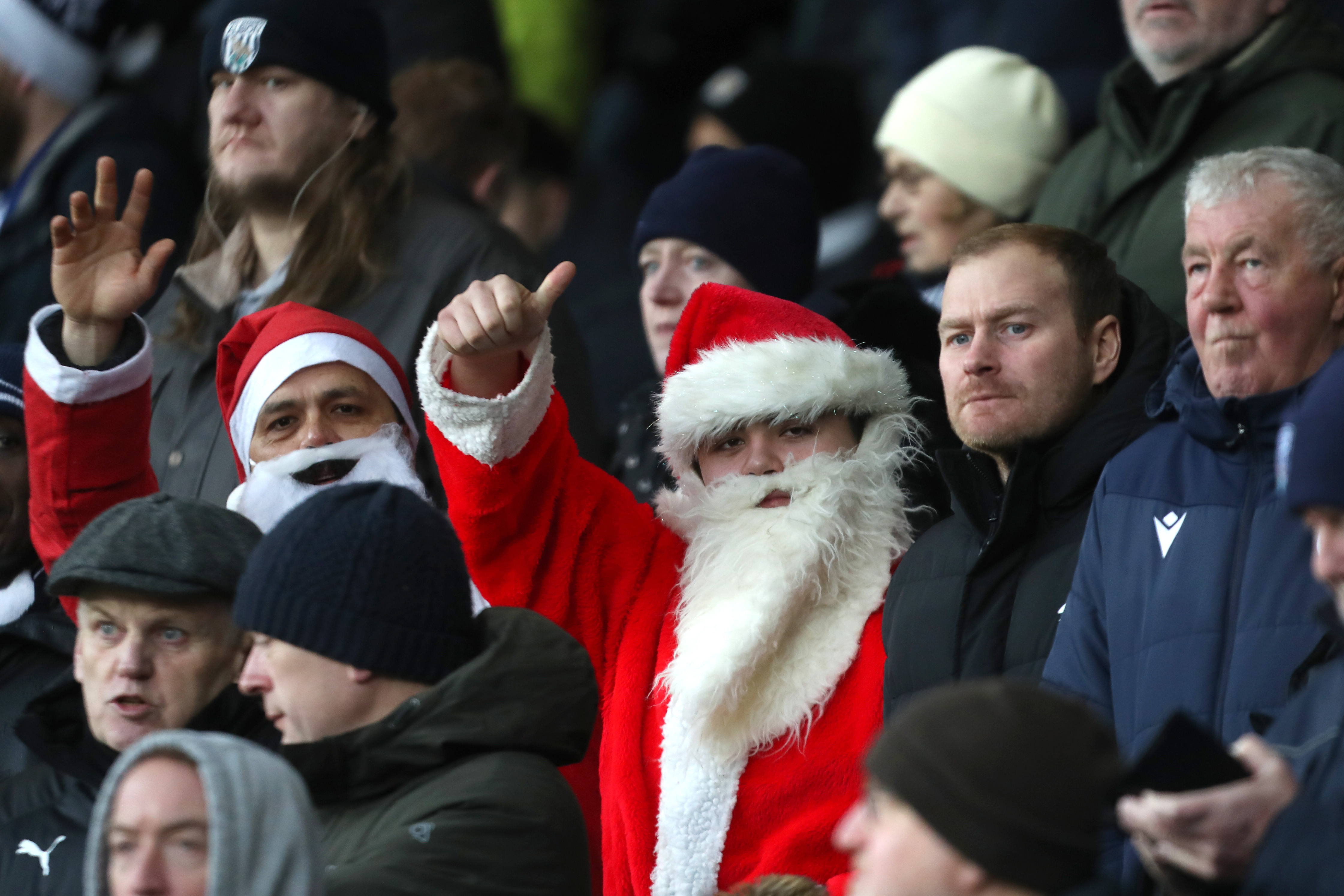 WBA fans wearing Santa hats waving at the camera 