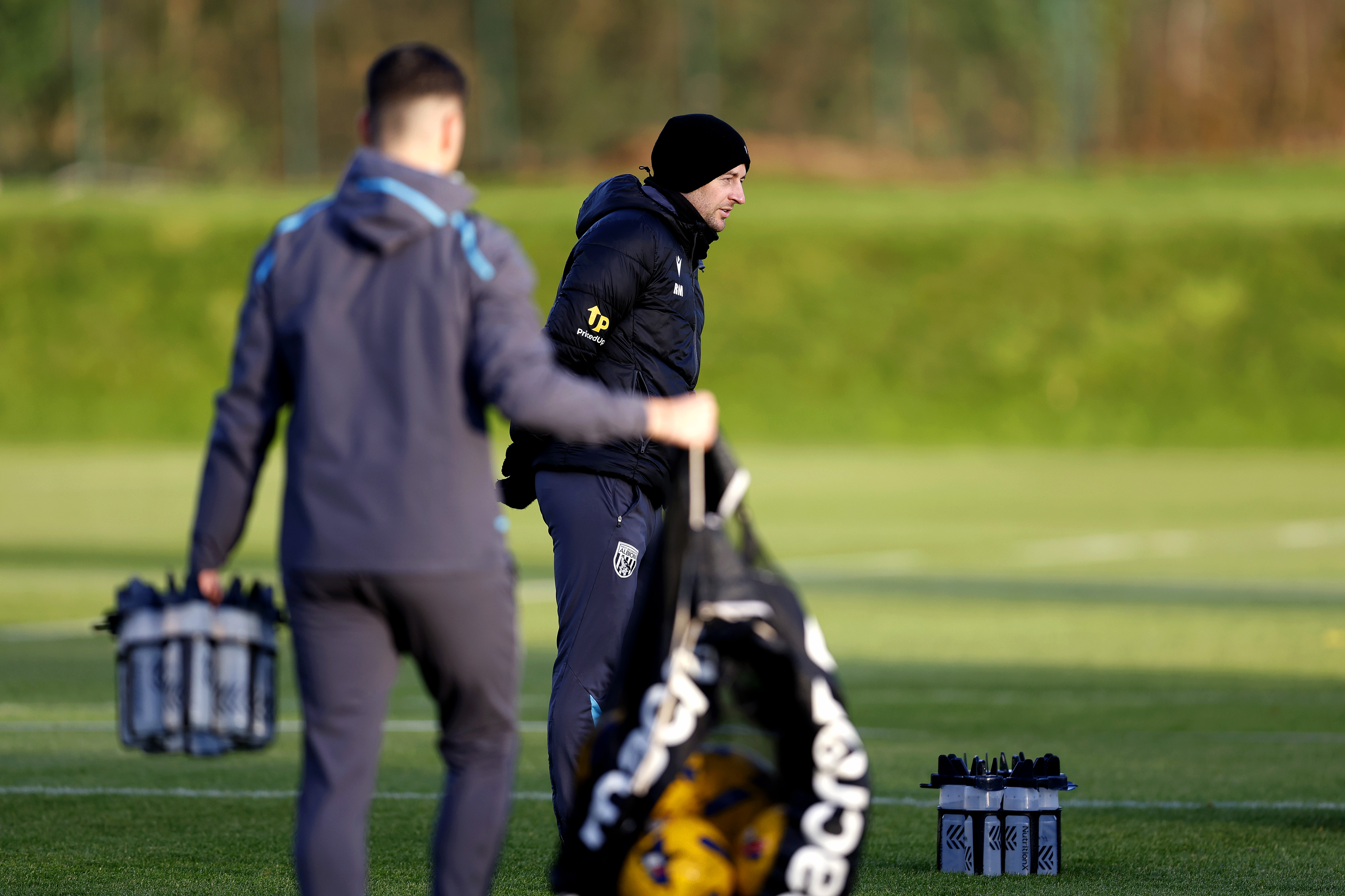 Ryan Mason watching training in a coat and a hat