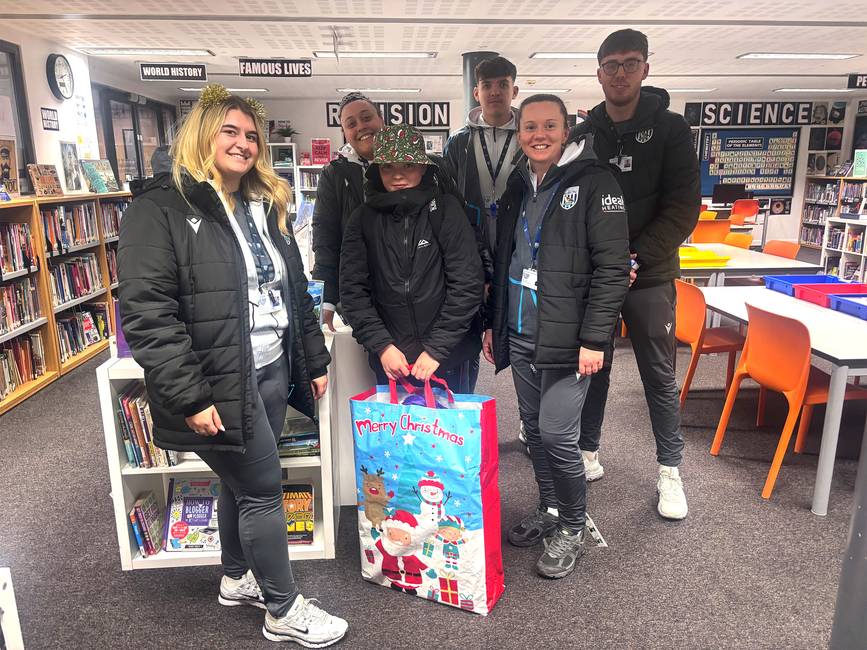 Foundation staff with a participant holding his gift bag.