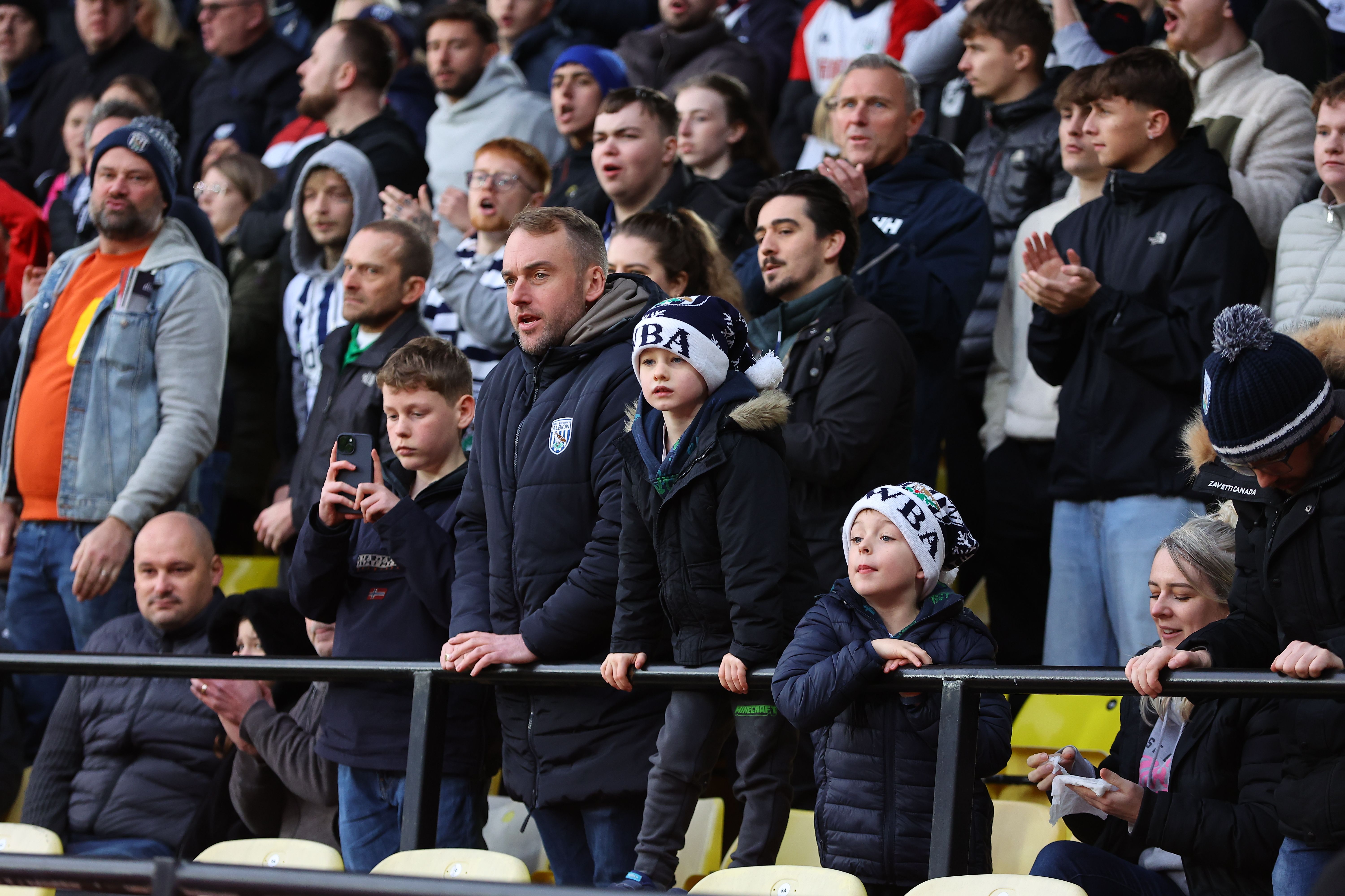 A general view of WBA fans in a stand with some wearing Christmas hats