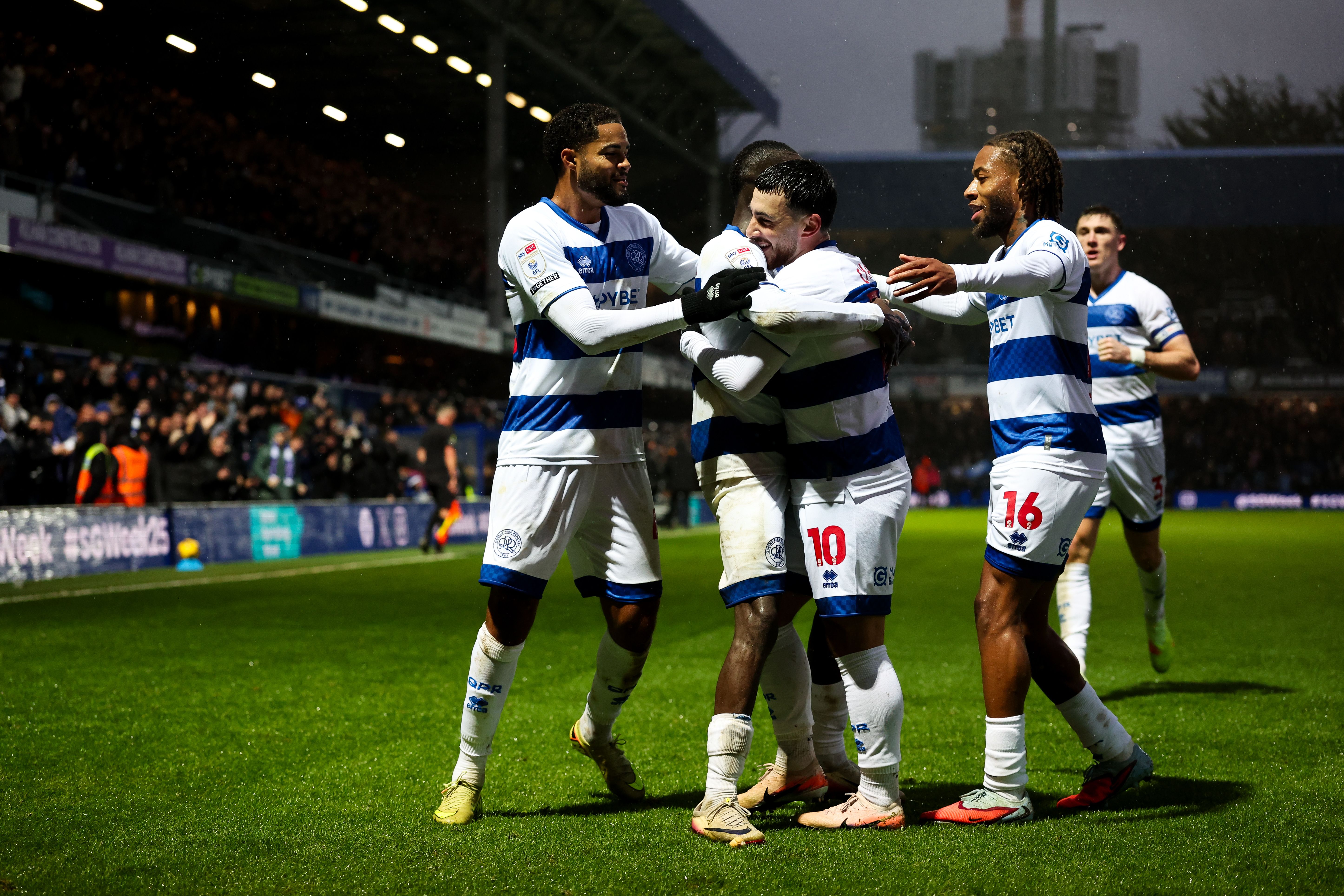 QPR players celebrate a goal scored at home in the home kit 