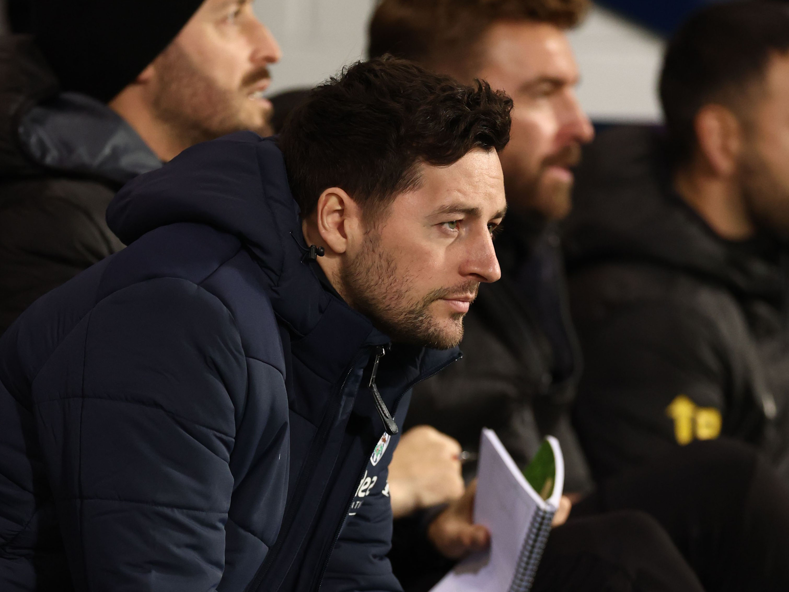 Ryan Mason sat in a coat in the dugout
