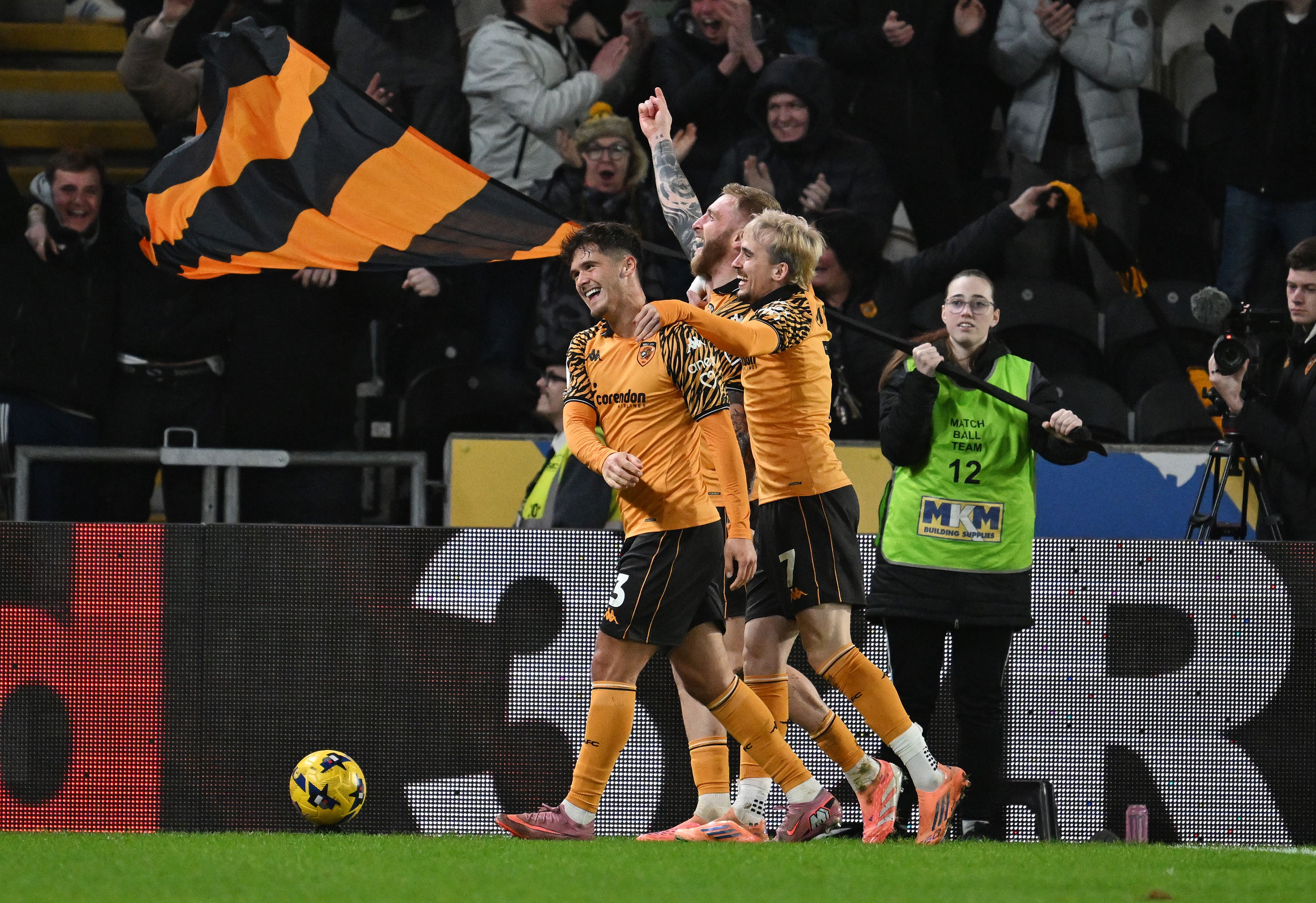 Hull City players celebrate after a goal in their home kit 