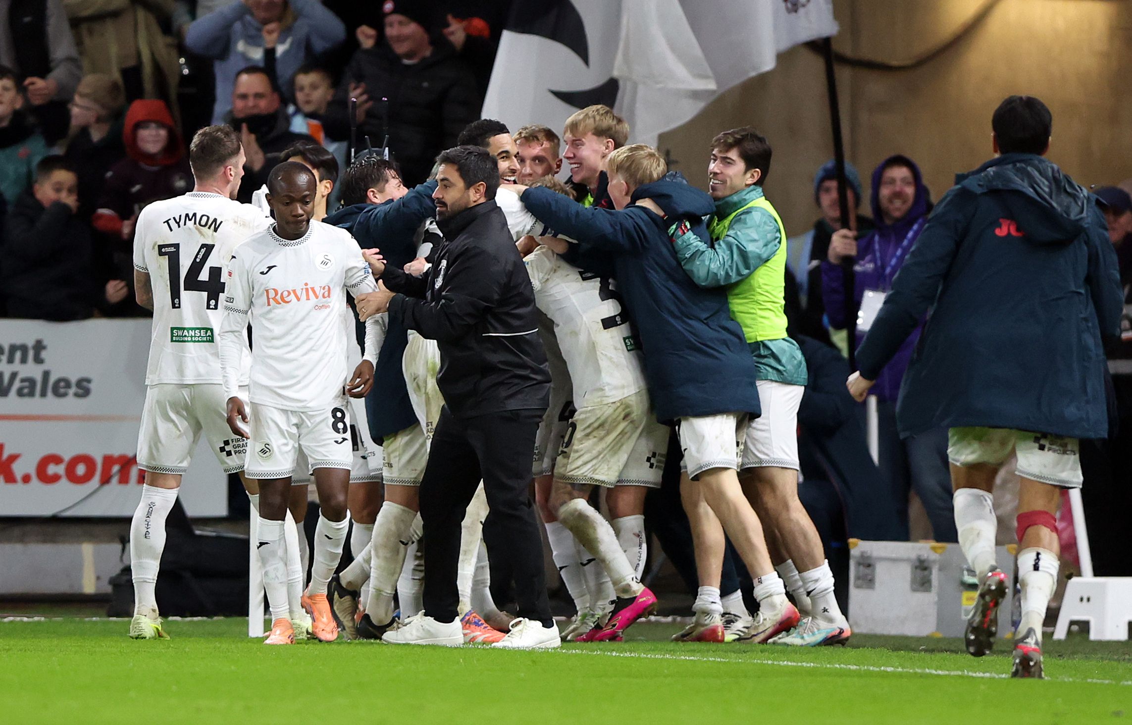 Swansea City players and staff celebrating a goal scored against Wrexham 