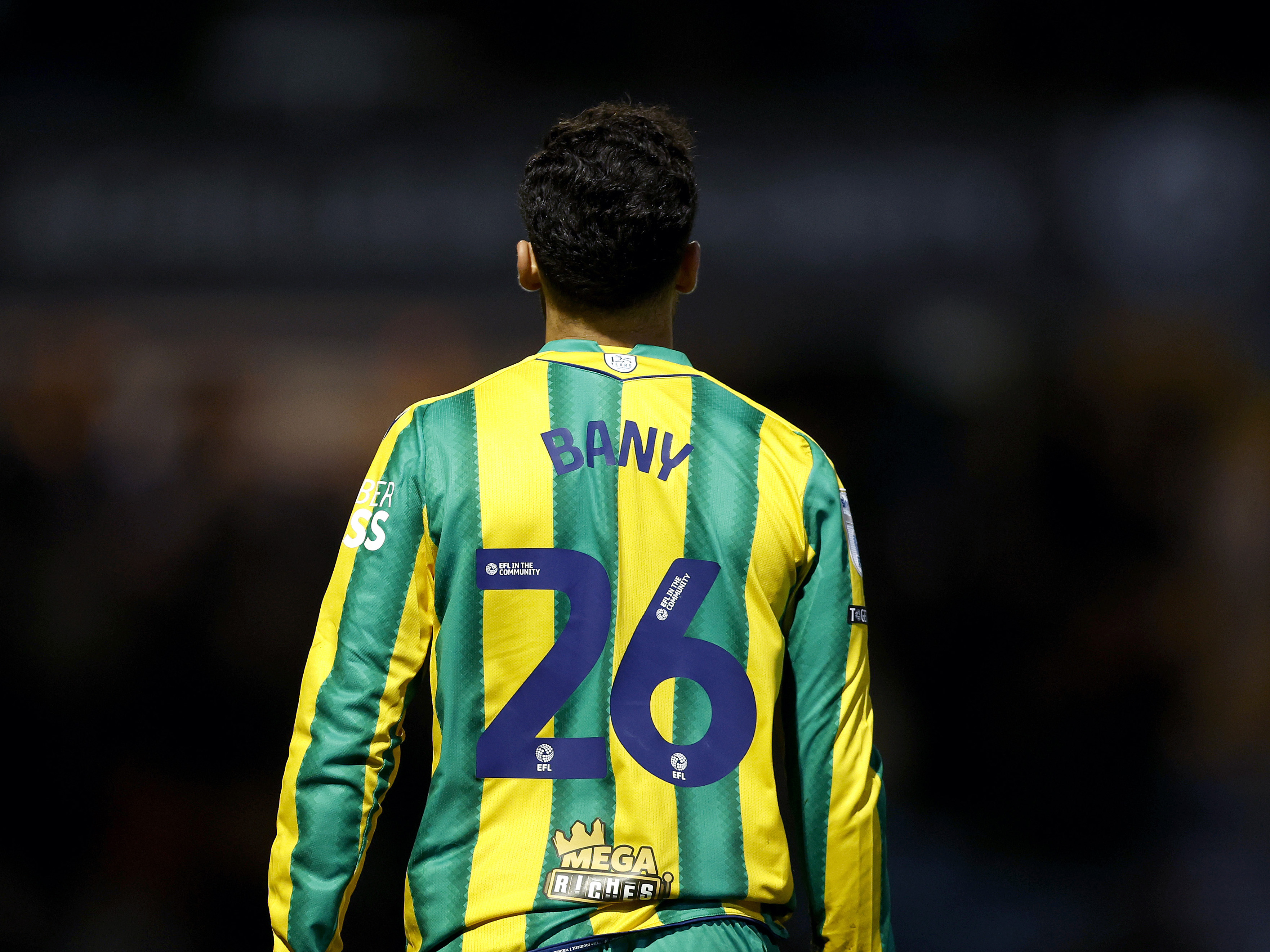 The back of Tammer Bany in the green and yellow shirt with his name and number 26 on show